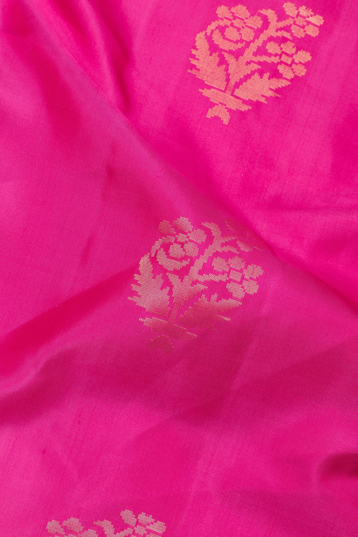 Close up of Pure Silk Dark Pink Soft Saree with Zari Butta on the body and Zari Border.  displaying folds