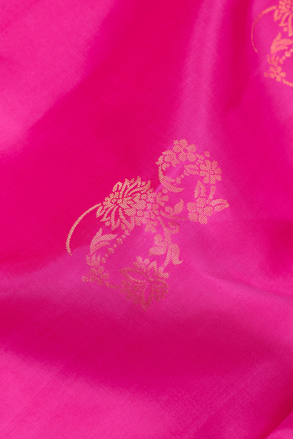 Close up of Pure Silk Rani Pink Soft Saree with Zari Butta on the body and Zari Border.  displaying folds