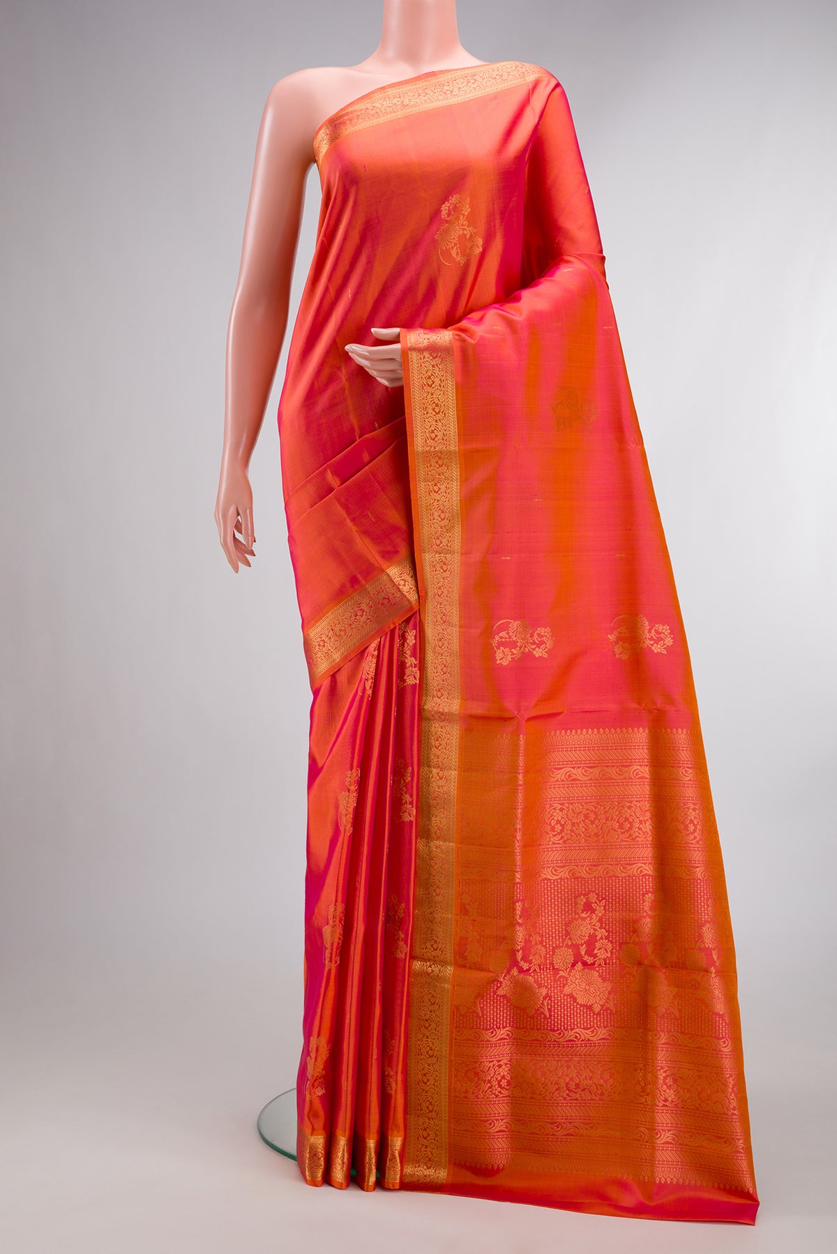 Pure Silk Coral Dual Tone Soft Saree with Zari Butta on the body and Zari Border.  displayed on a mannequin
