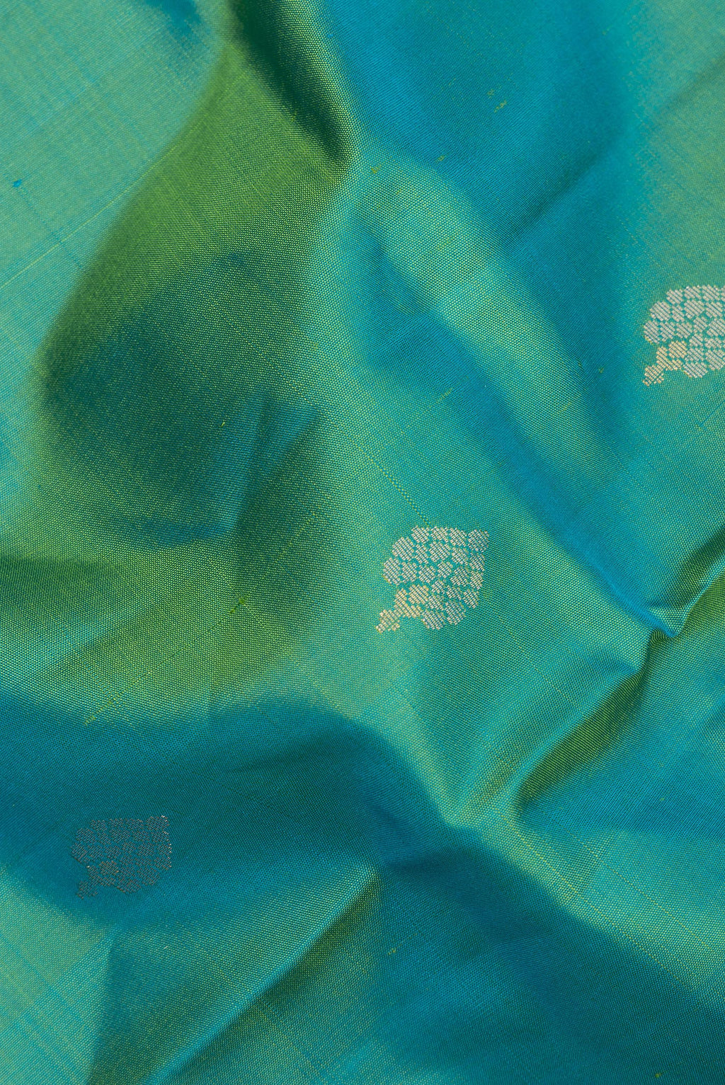 Close up of Pure Silk Turquoise Dual Tone Soft Saree with Zari Butta on the body and Zari Border.  displaying folds