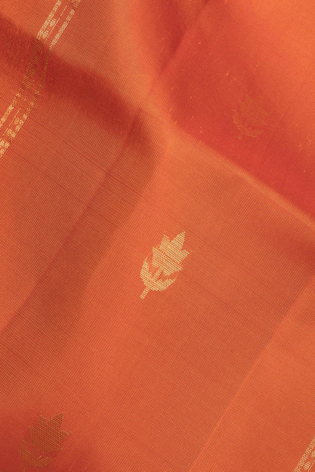 Close up of Pure Silk Rust Dual Tone Soft Saree with Stripes on the body and Without Border.  displaying folds