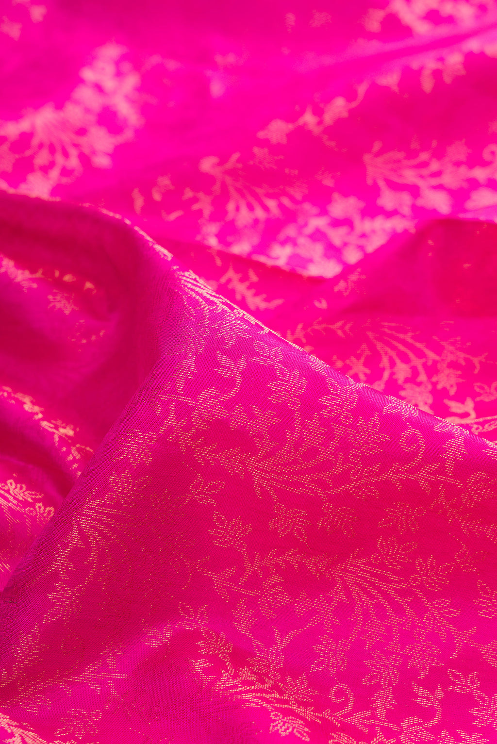 Close up of Pure Silk Rani Pink Soft Saree with Zari Brocade on the body and Fancy Border.  displaying folds