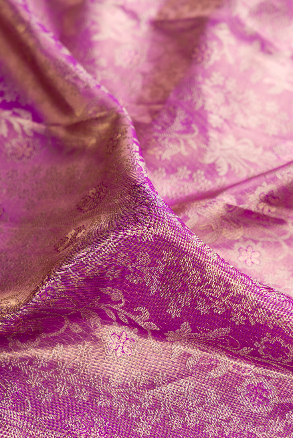 Close up of Light Magenta Dual Tone Kanjivaram Tissue Saree with Zari Brocade on the body and Zari Border.  displaying folds