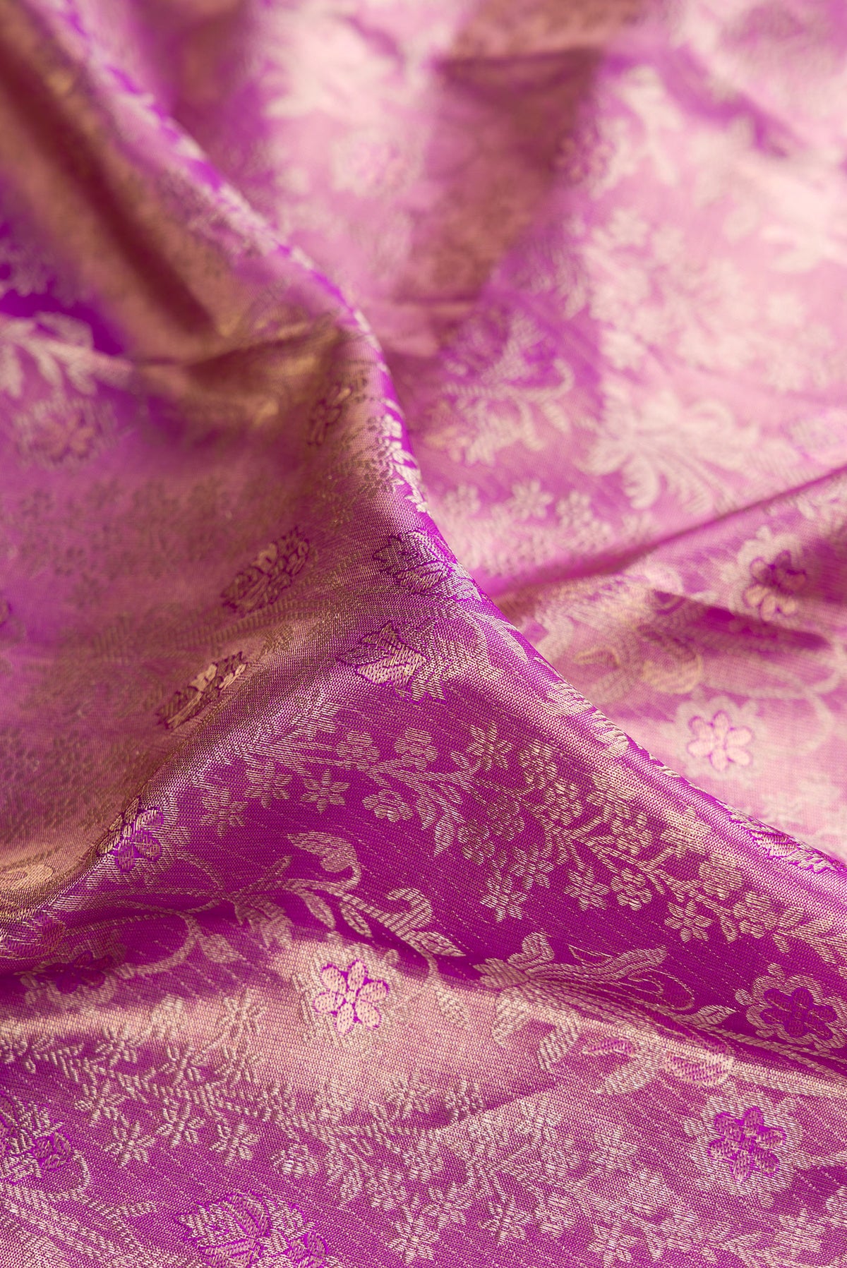 Close up of Light Magenta Dual Tone Kanjivaram Tissue Saree with Zari Brocade on the body and Zari Border.  displaying folds