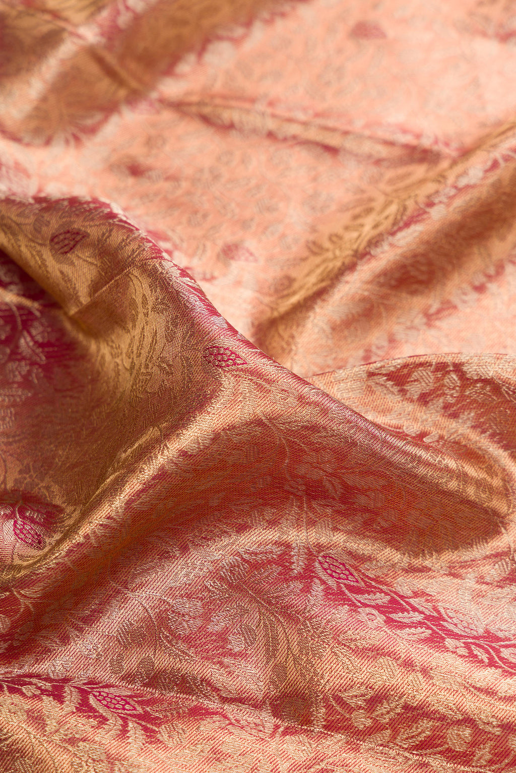 Close up of Gold with Red Color Kanjivaram Tissue Saree with Zari Brocade on the body and Zari Border.  displaying folds