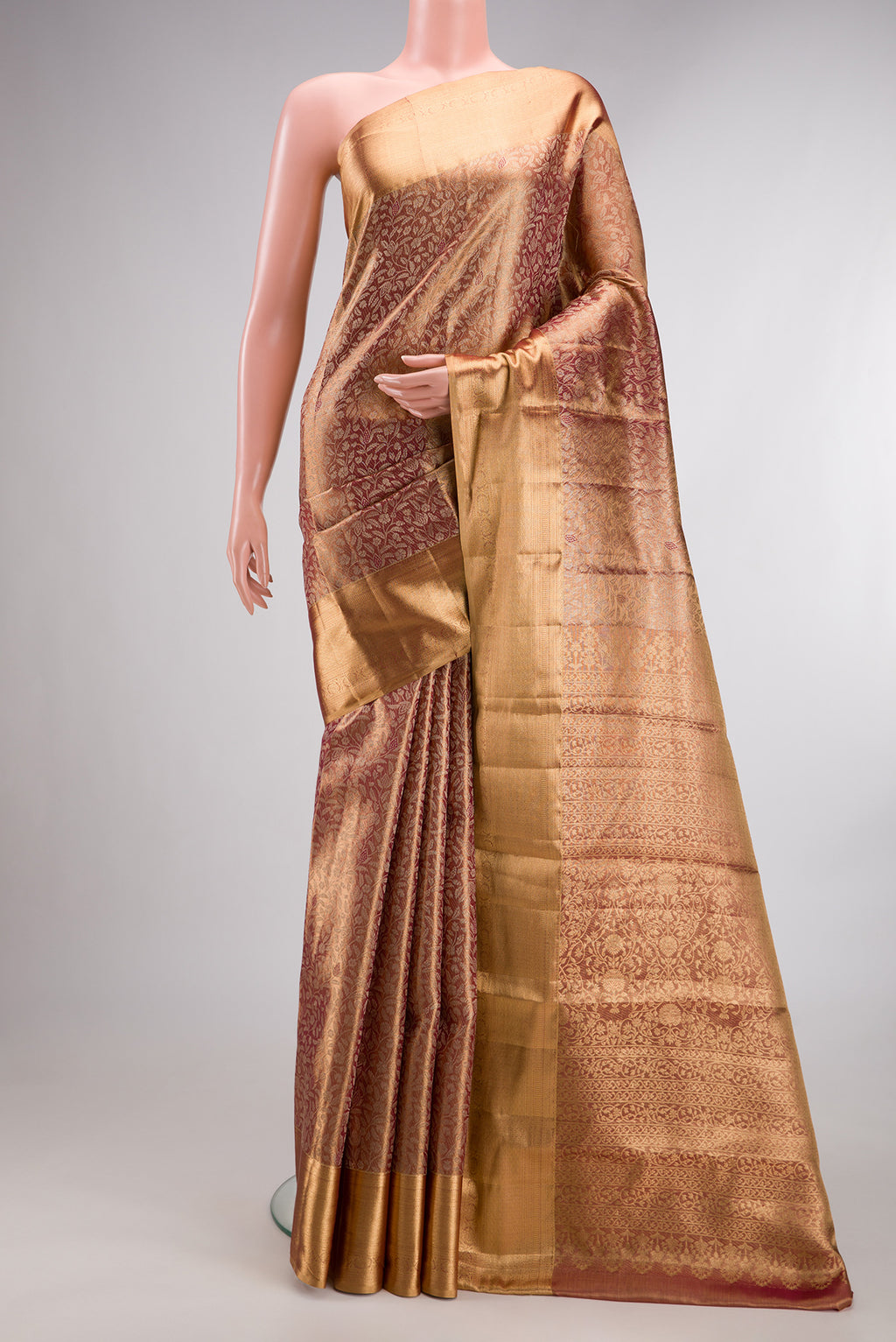 Gold with Red Color Kanjivaram Tissue Saree with Zari Brocade on the body and Zari Border.  displayed on a mannequin