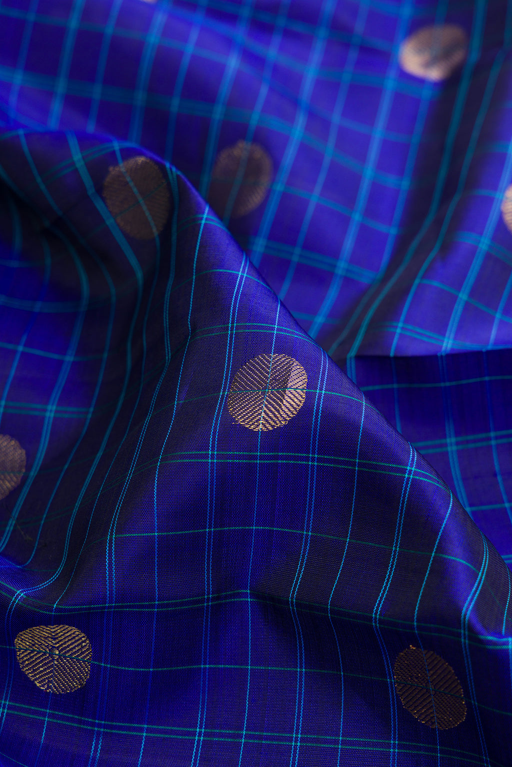 Close up of Pure Silk Royal Blue Kanchipuram Saree with Checked design on the body and Zari Border.  displaying folds