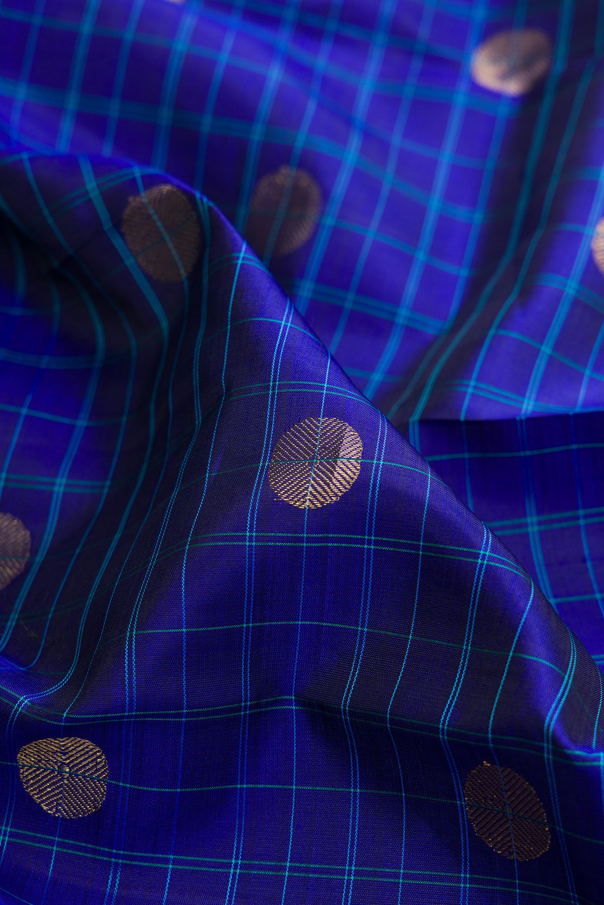 Close up of Pure Silk Royal Blue Kanchipuram Saree with Checked design on the body and Zari Border.  displaying folds