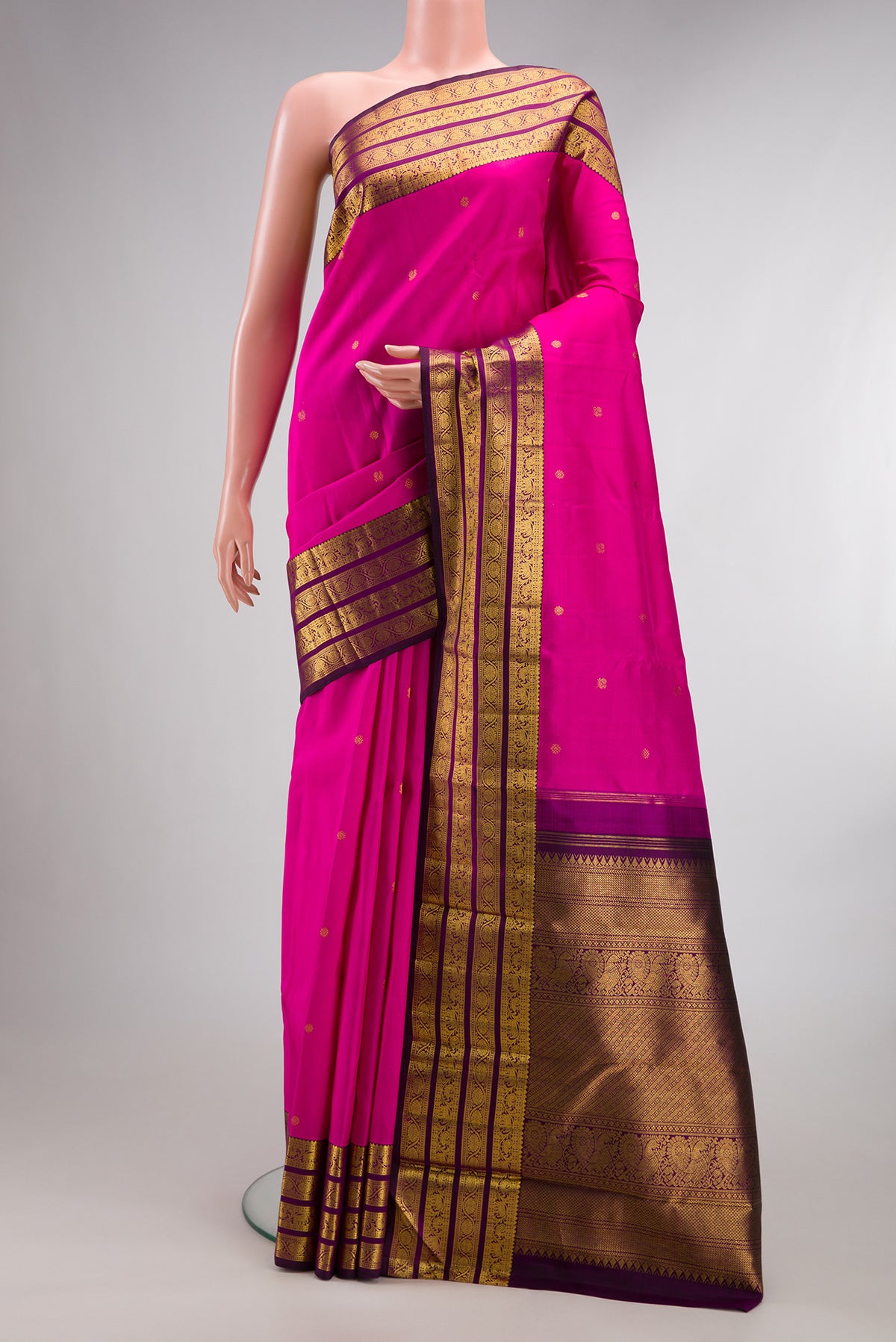 Pure Silk Rani Pink Kanchipuram Saree with Zari Butta on the body and Zari Border.  displayed on a mannequin