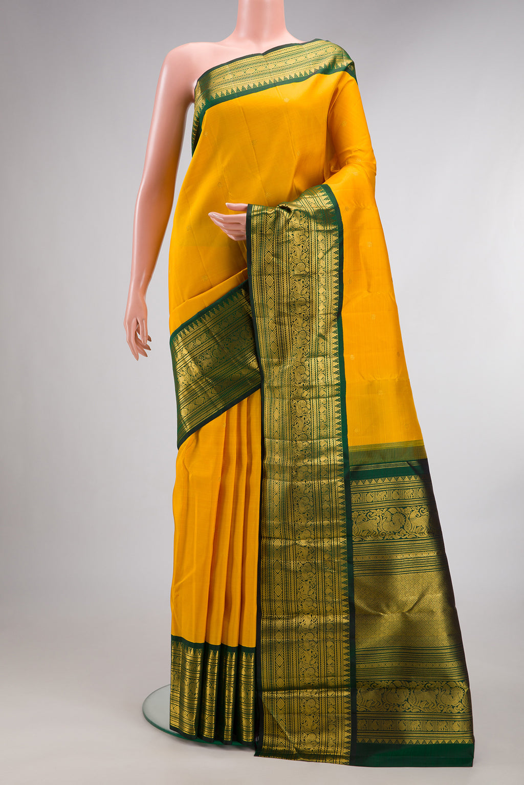 Pure Silk Mustard Kanchipuram Saree with Zari Butta on the body and Fancy Border.  displayed on a mannequin