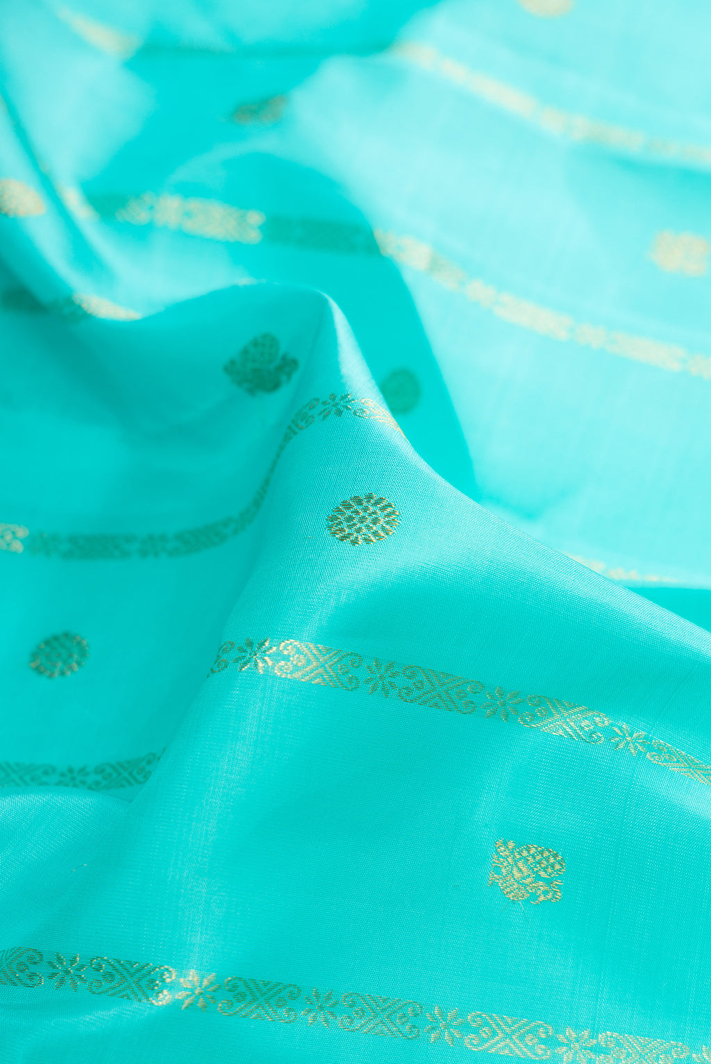 Close up of Pure Silk Turquoise Kanchipuram Saree with Stripes on the body and Ganga Jamuna Border.  displaying folds