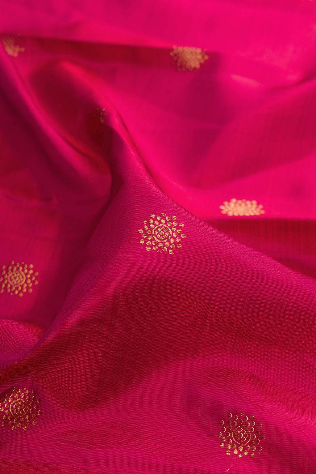Close up of Pure Silk Dark Pink Kanchipuram Saree with Zari Butta on the body and Zari Border.  displaying folds