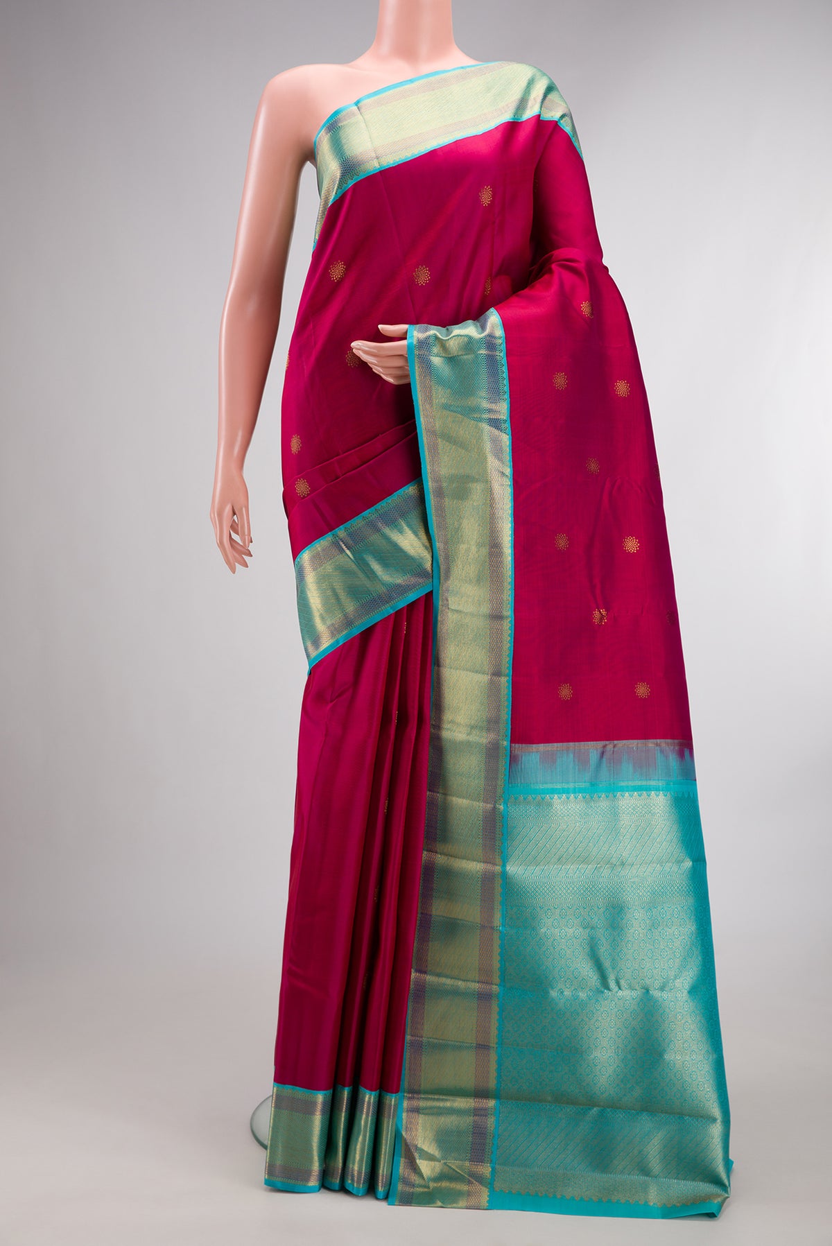 Pure Silk Dark Pink Kanchipuram Saree with Zari Butta on the body and Zari Border.  displayed on a mannequin