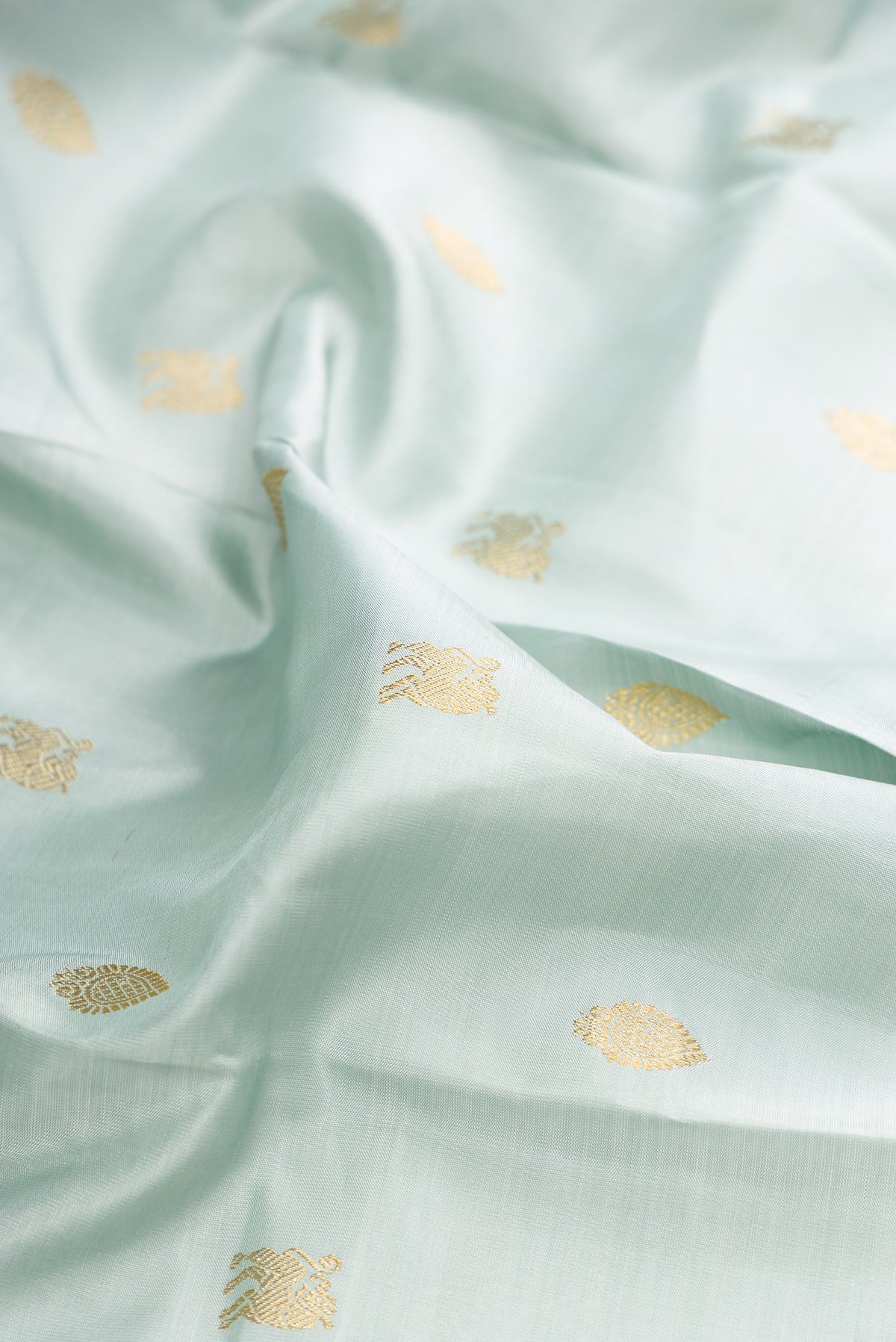 Close up of Pure Silk Light Blue Kanjivaram Saree with Zari Butta on the body and Zari Border.  displaying folds