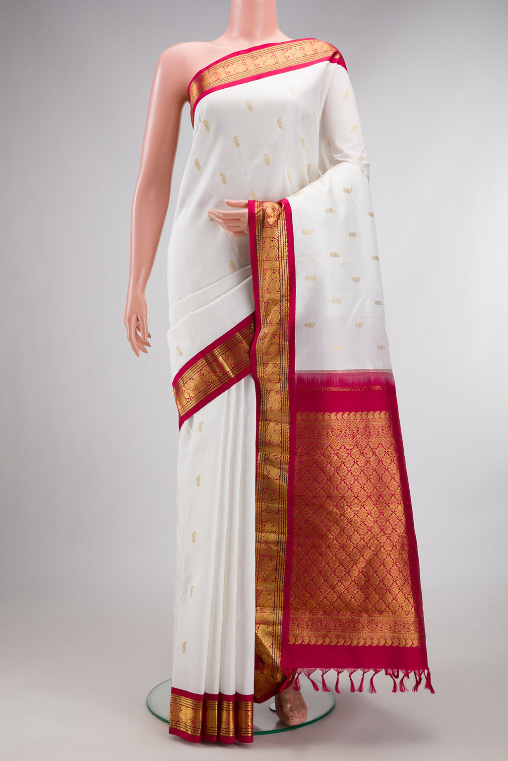 Pure Silk White Kanjivaram Saree with Zari Butta on the body and Zari Border.  displayed on a mannequin