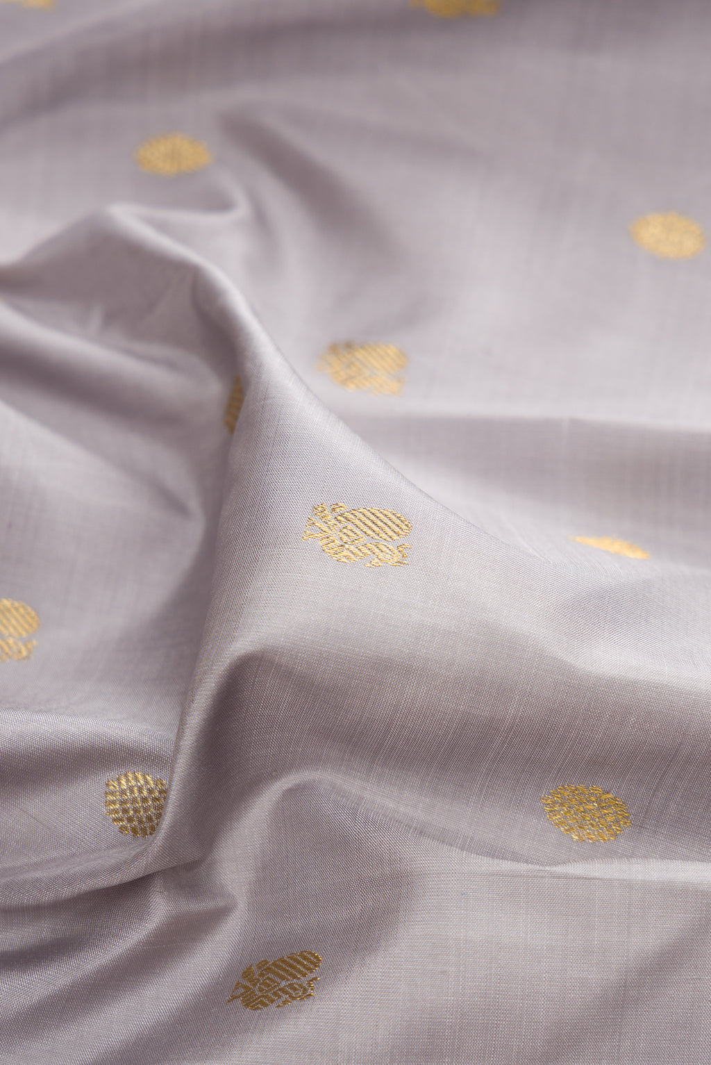Close up of Pure Silk Grey Kanchipuram Saree with Zari Butta on the body and Zari Border.  displaying folds