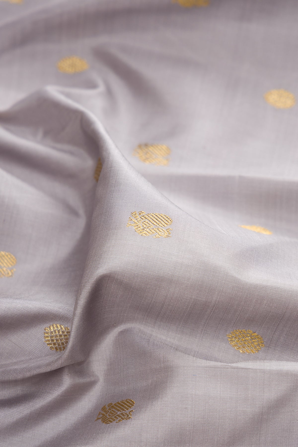 Close up of Pure Silk Grey Kanchipuram Saree with Zari Butta on the body and Zari Border.  displaying folds