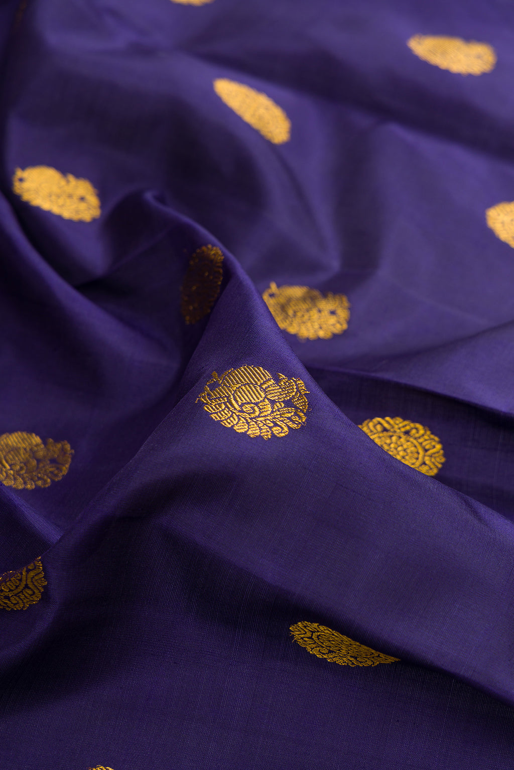 Close up of Pure Silk Navy Blue Kanjivaram Saree with Zari Butta on the body and Zari Border.  displaying folds