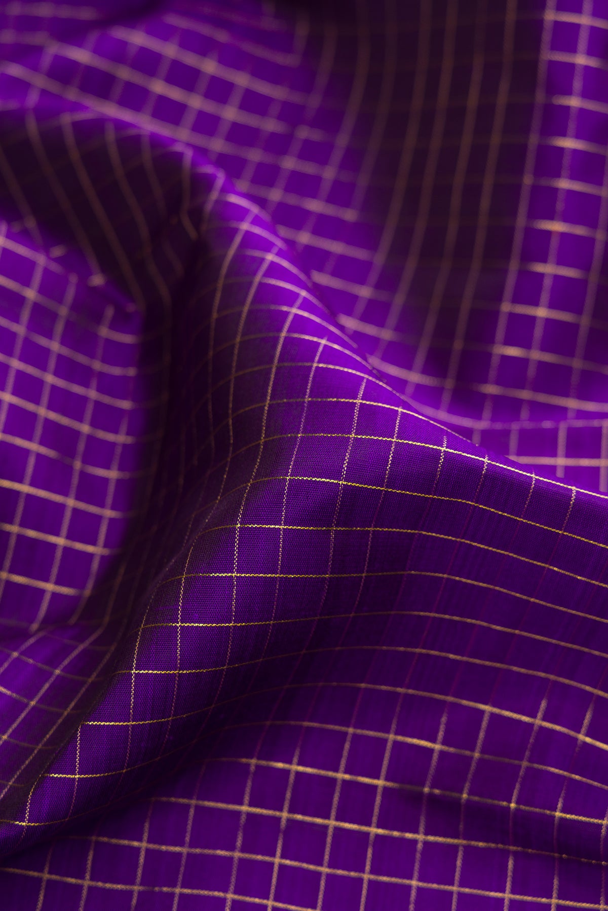 Close up of Pure Silk Pure Zari Violet Kanchipuram Saree with Checked design on the body and Fancy Border.  displaying folds