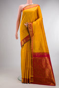 Pure Silk Mustard Kanjivaram Saree with Zari Butta on the body and Zari Border.  displayed on a mannequin