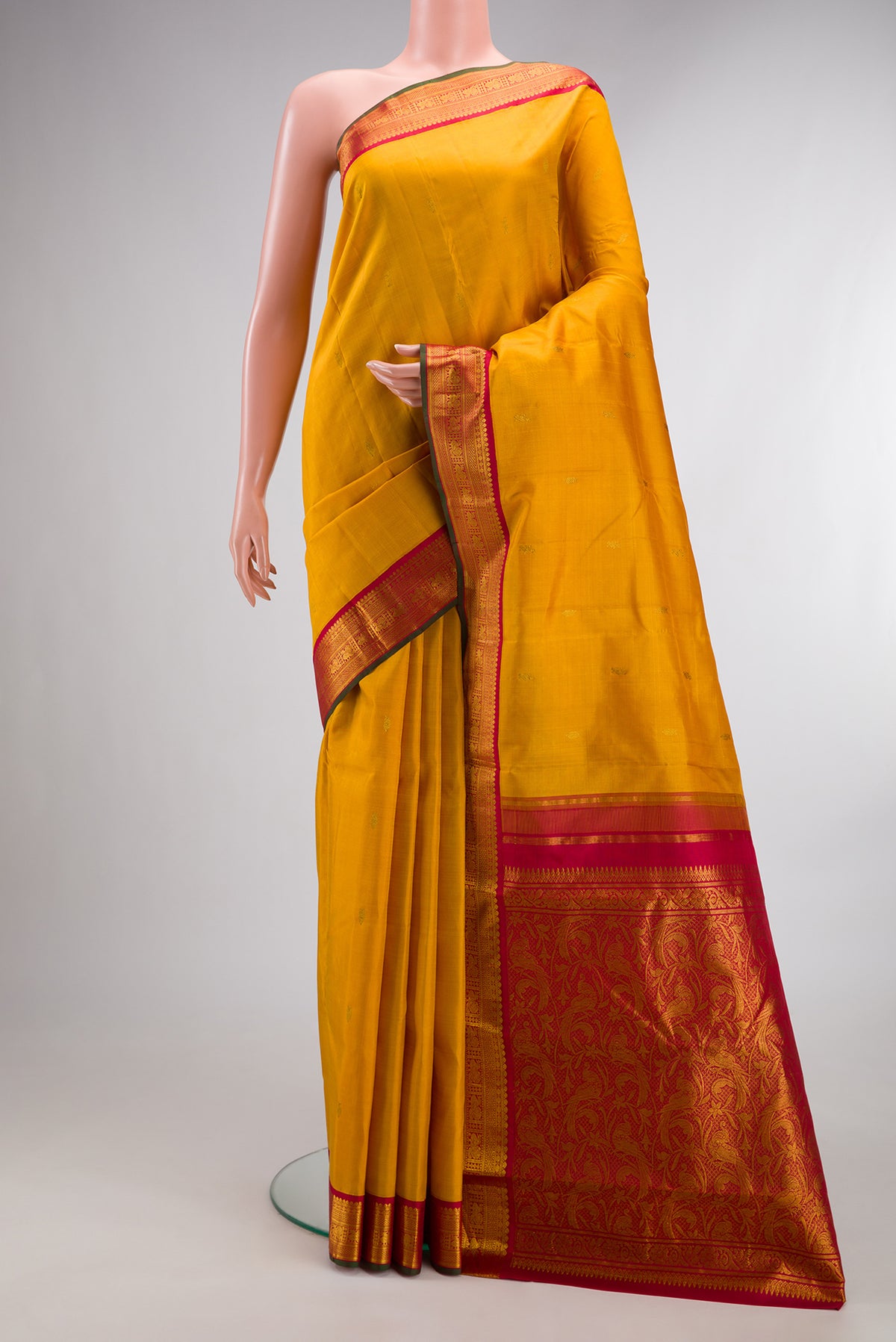 Pure Silk Mustard Kanjivaram Saree with Zari Butta on the body and Zari Border.  displayed on a mannequin