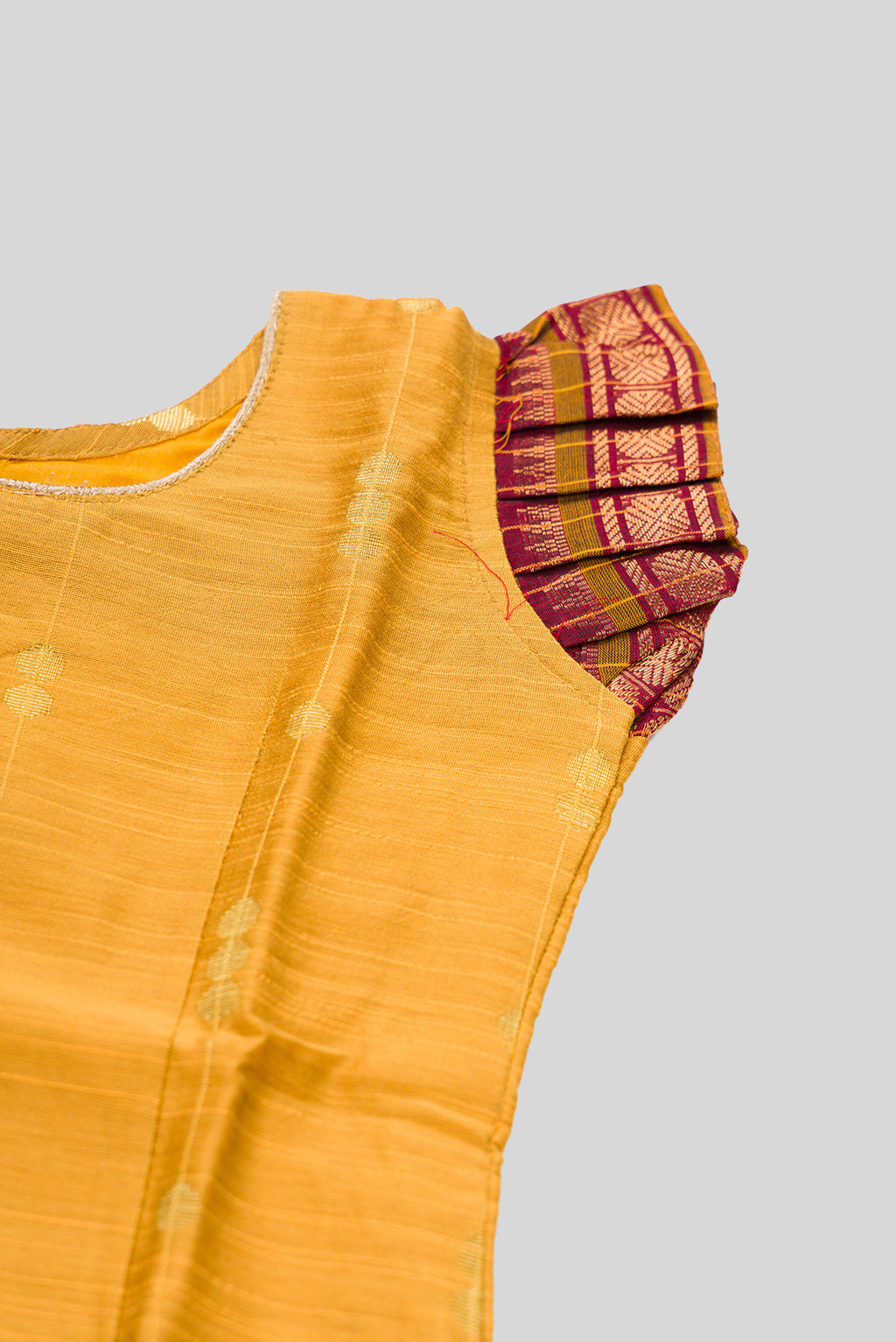 Close up sleeve details of Mustard Readymade Cotton Pavadai Set with Zari Butta on the body and Zari Border