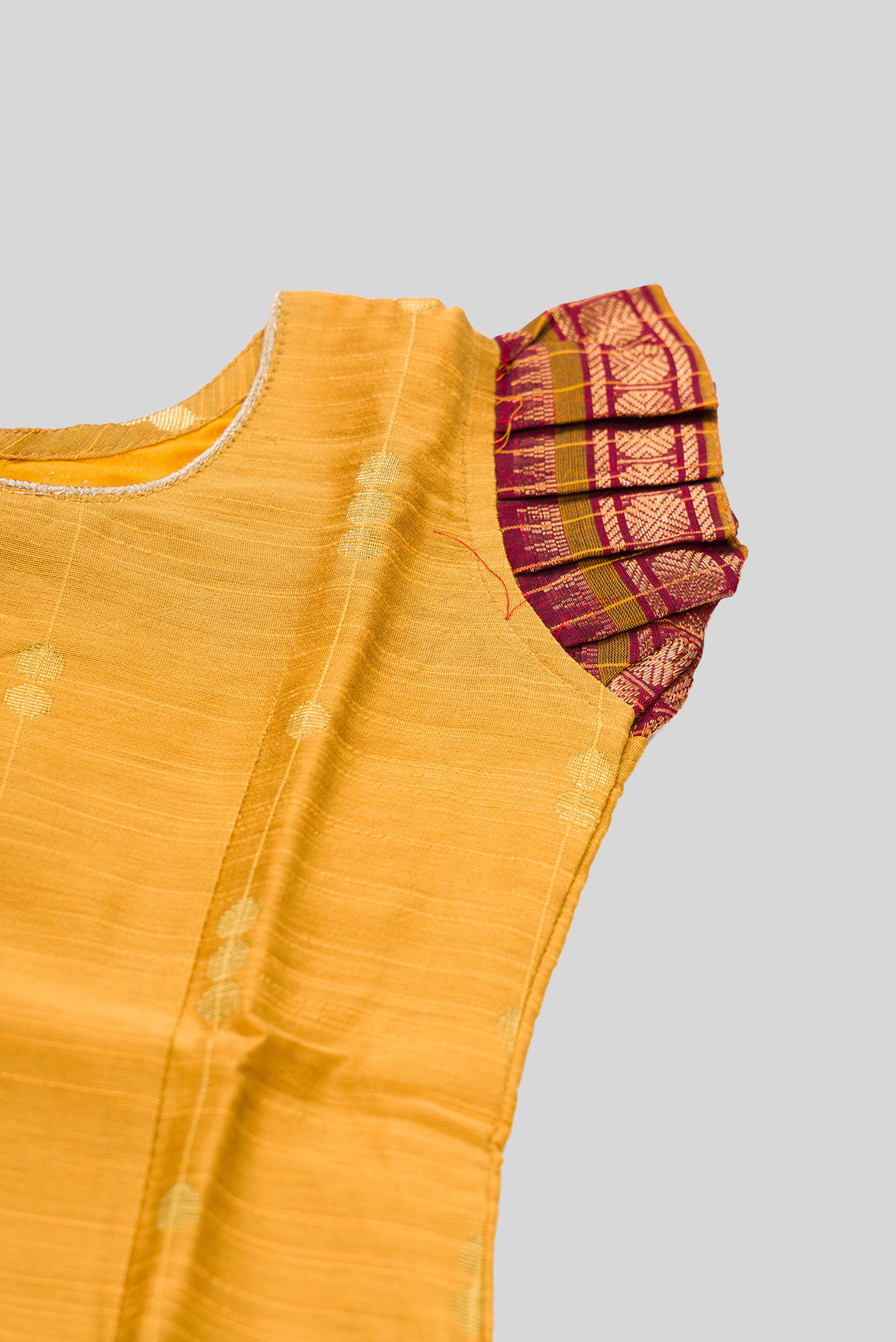Close up sleeve details of Mustard Readymade Cotton Pavadai Set with Zari Butta on the body and Zari Border