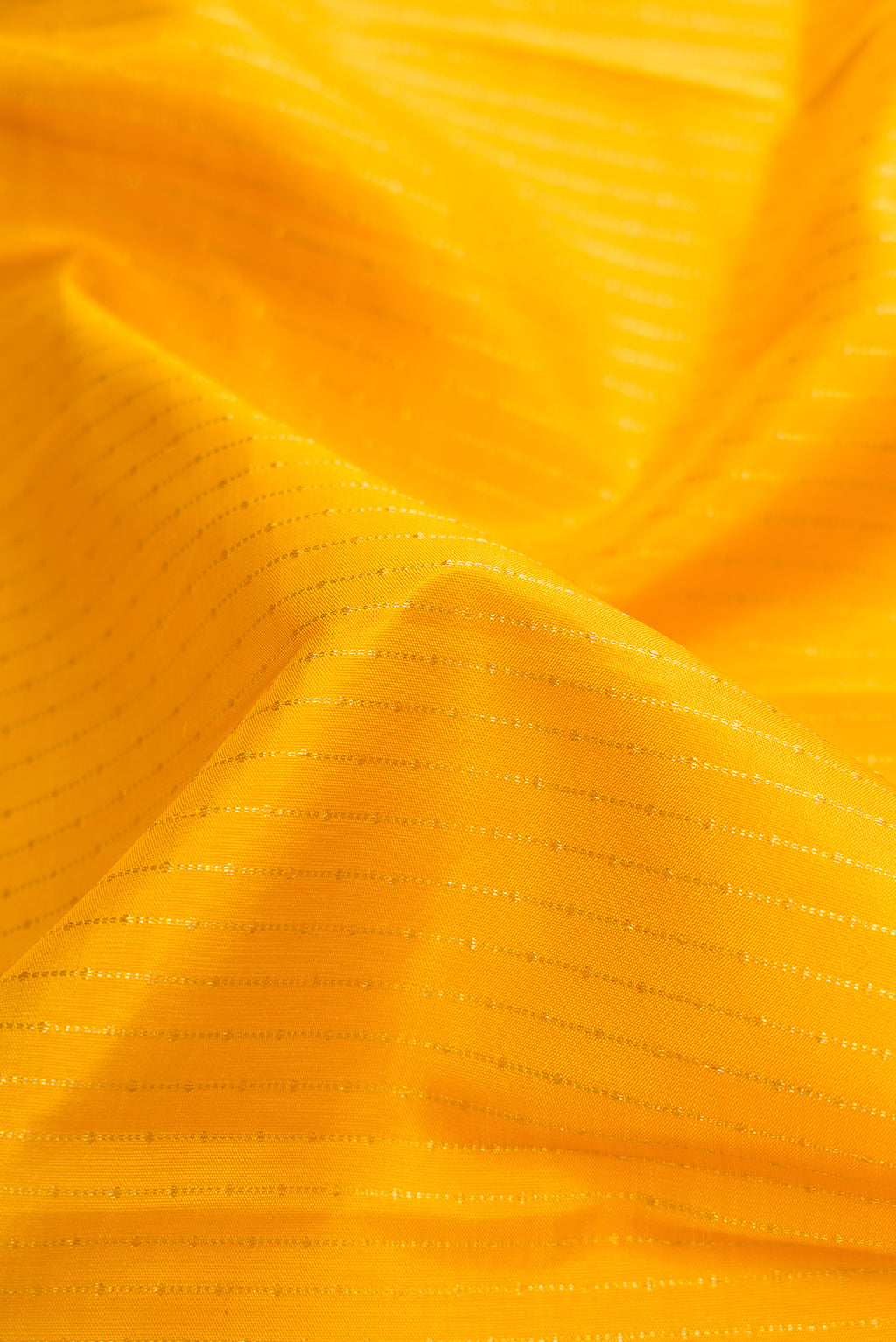 Close up of Mustard Dual Tone Kanchipuram Silk Saree with Stripes on the body and Zari Border.  displaying folds