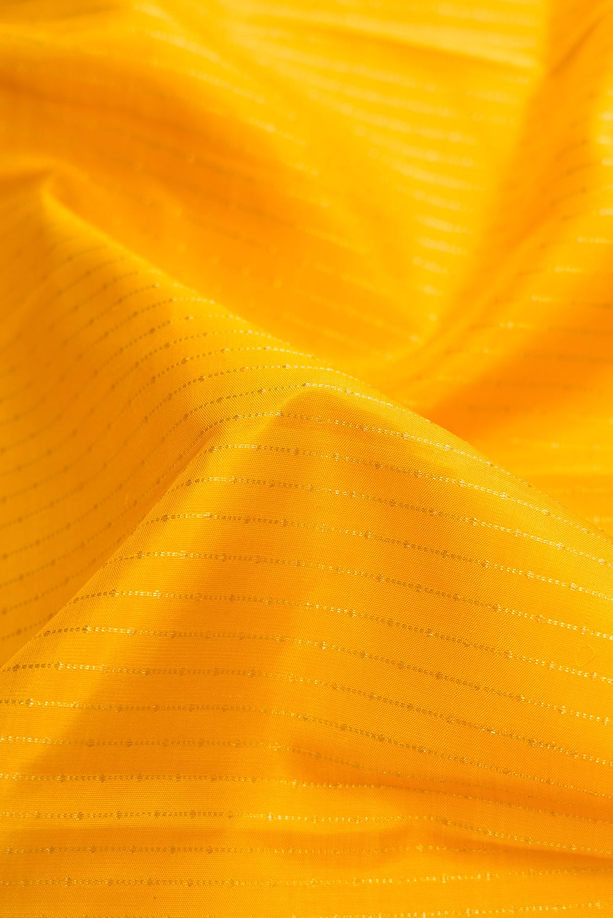 Close up of Mustard Dual Tone Kanchipuram Silk Saree with Stripes on the body and Zari Border.  displaying folds