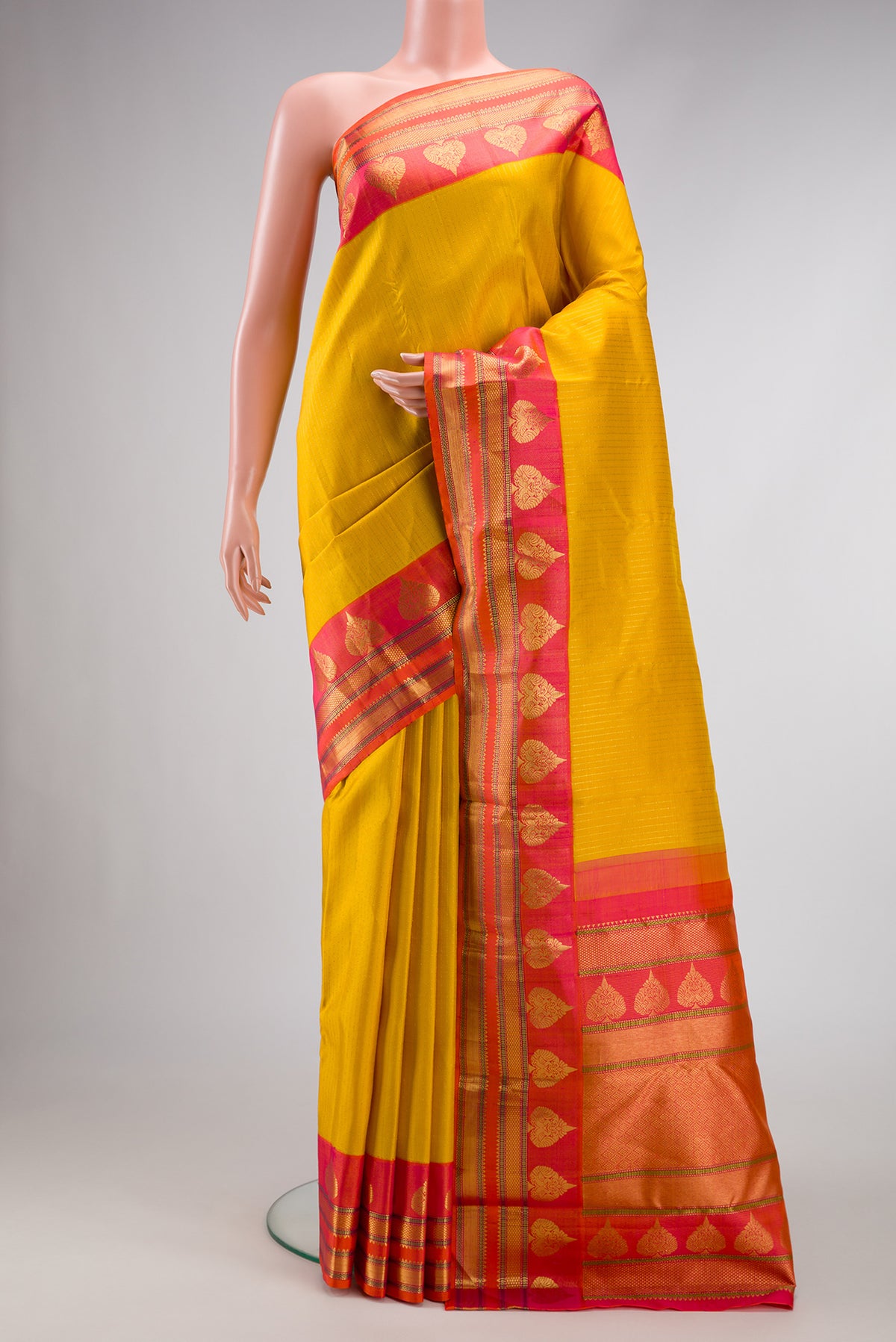 Mustard Dual Tone Kanchipuram Silk Saree with Stripes on the body and Zari Border.  displayed on a mannequin