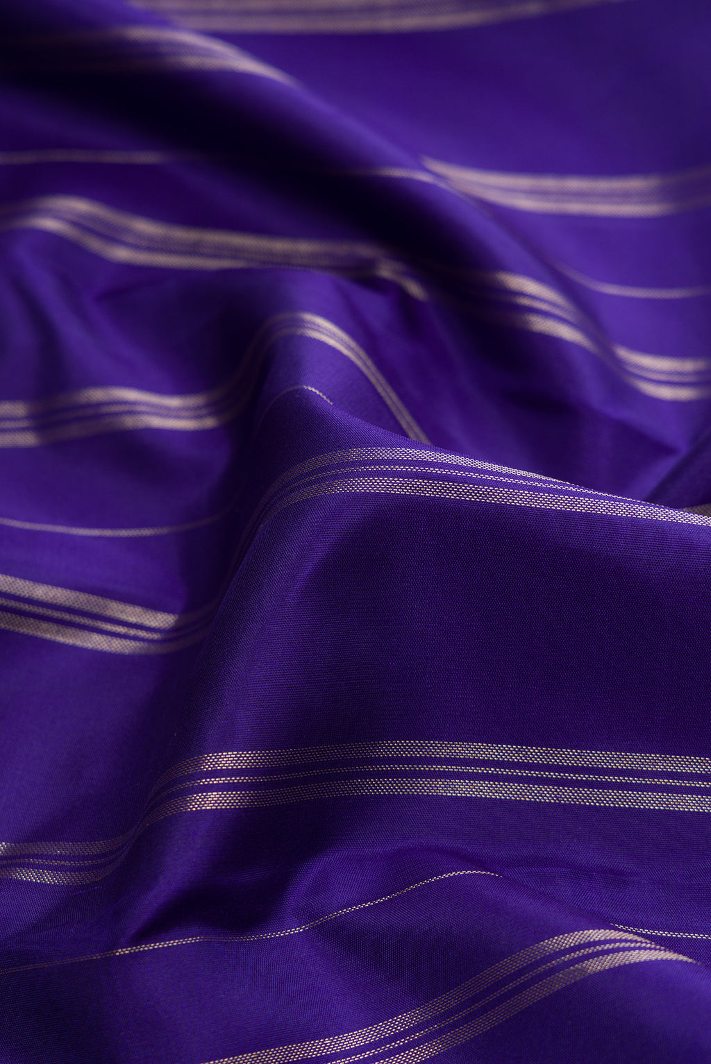 Close up of Royal Blue Dual Tone Kanjivaram Silk Saree with Stripes on the body and Fancy Border.  displaying folds