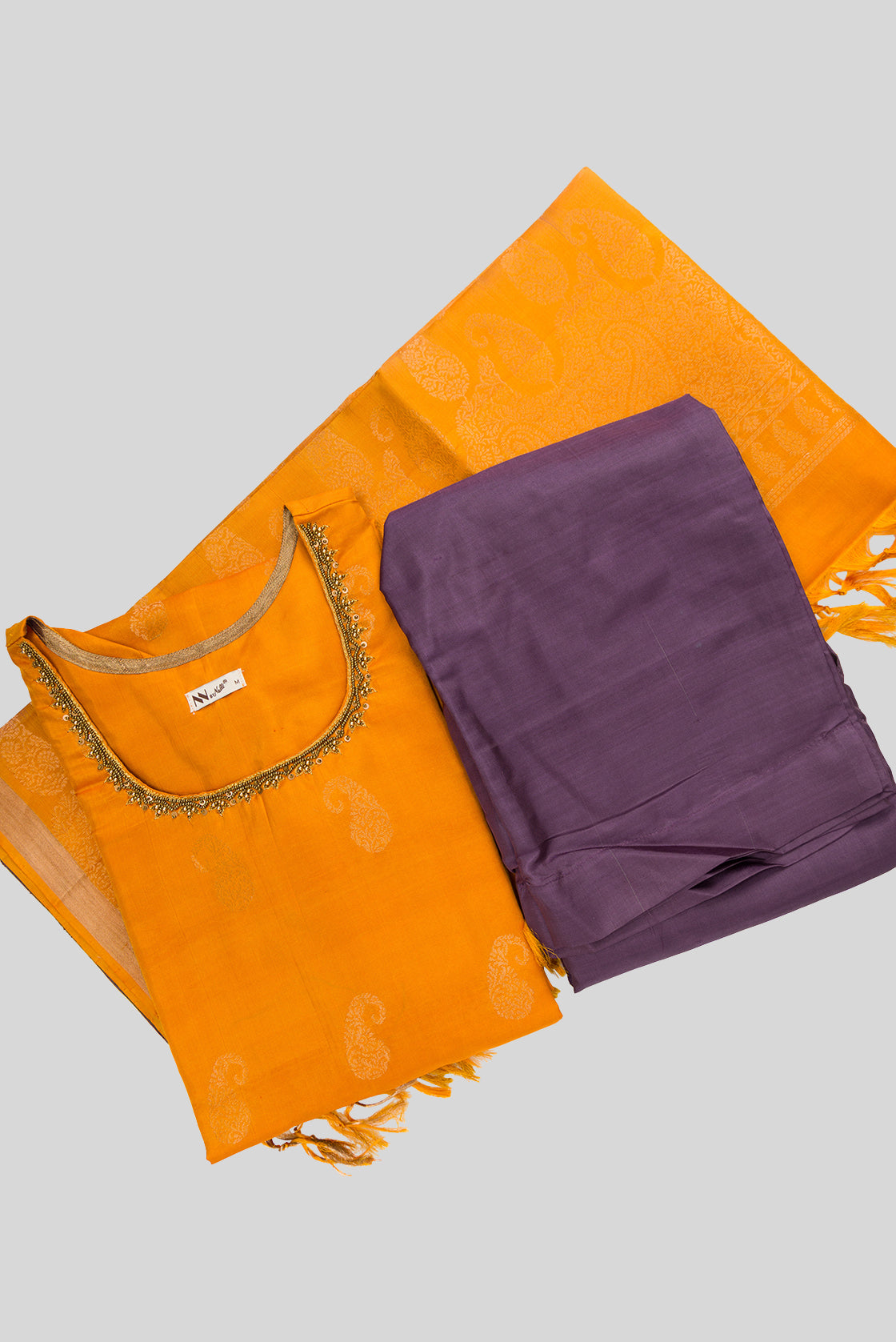 Flat lay of Mustard Pure Silk Womens Kurta set featuring Zari Butta Kurta paired with Lavender Plain Body bottom and a Zari Butta dupatta in Lavender