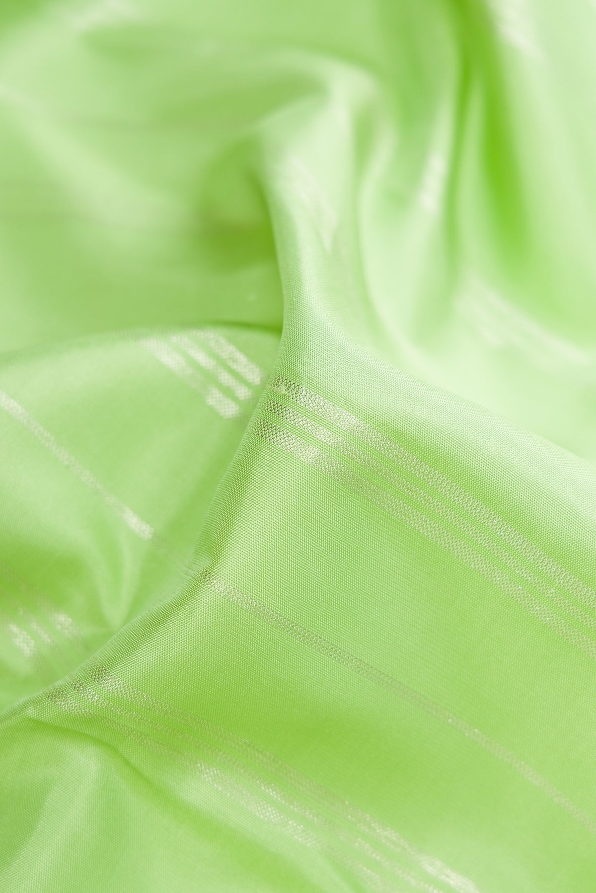 Close up of Pista Green Kanjivaram Silk Saree with Stripes on the body and Without Border.  displaying folds