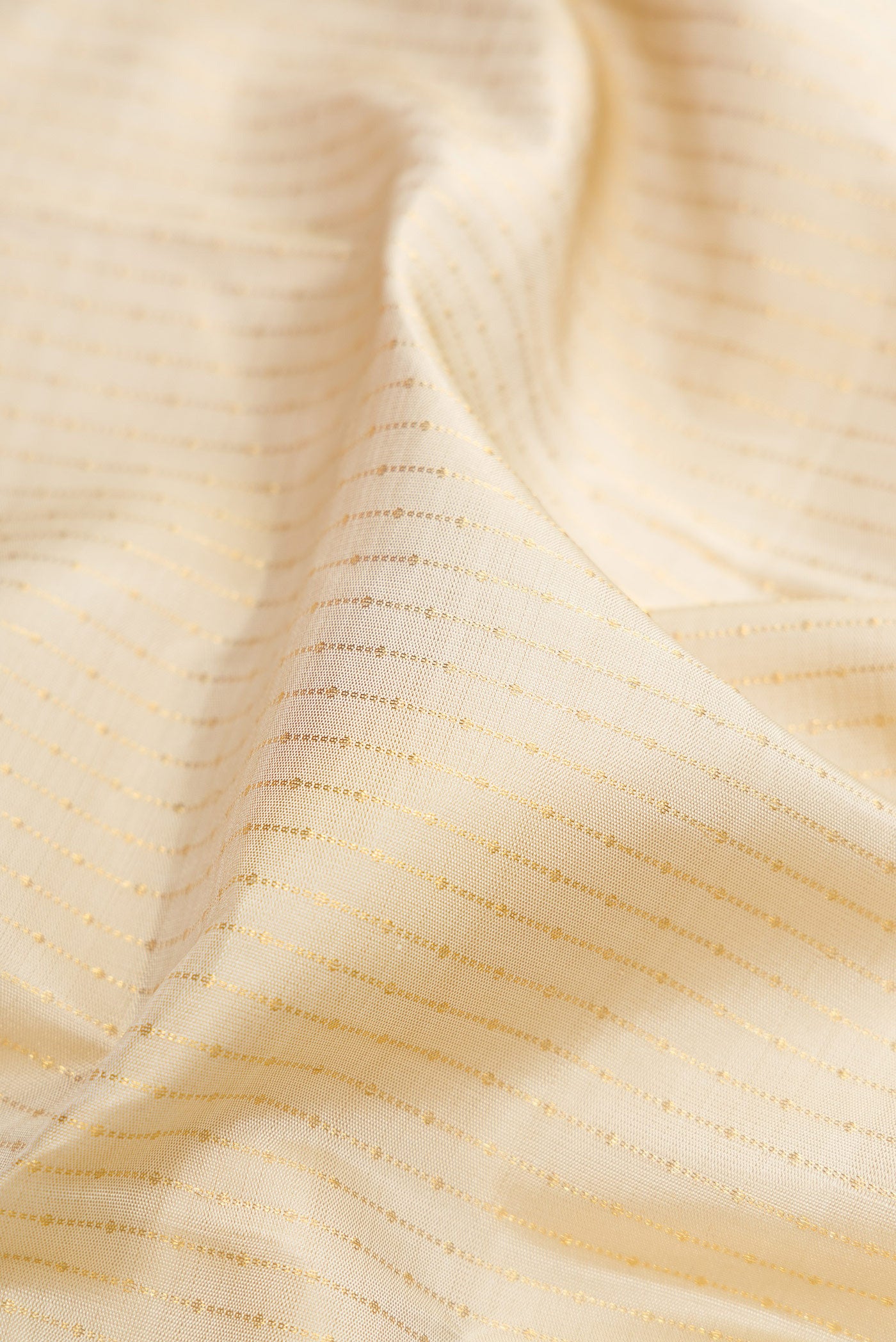 Close up of Beige Dual Tone Kanchipuram Silk Saree with Stripes on the body and Fancy Border.  displaying folds