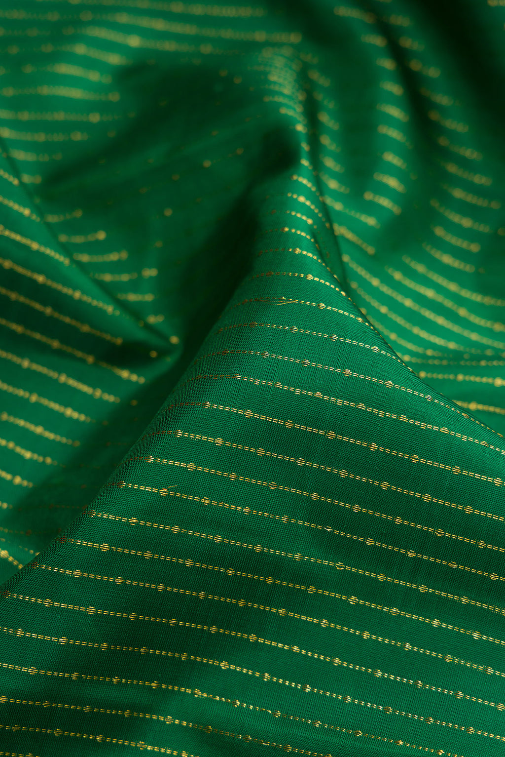 Close up of Bottle Green Kanchipuram Silk Saree with Stripes on the body and Zari Border.  displaying folds