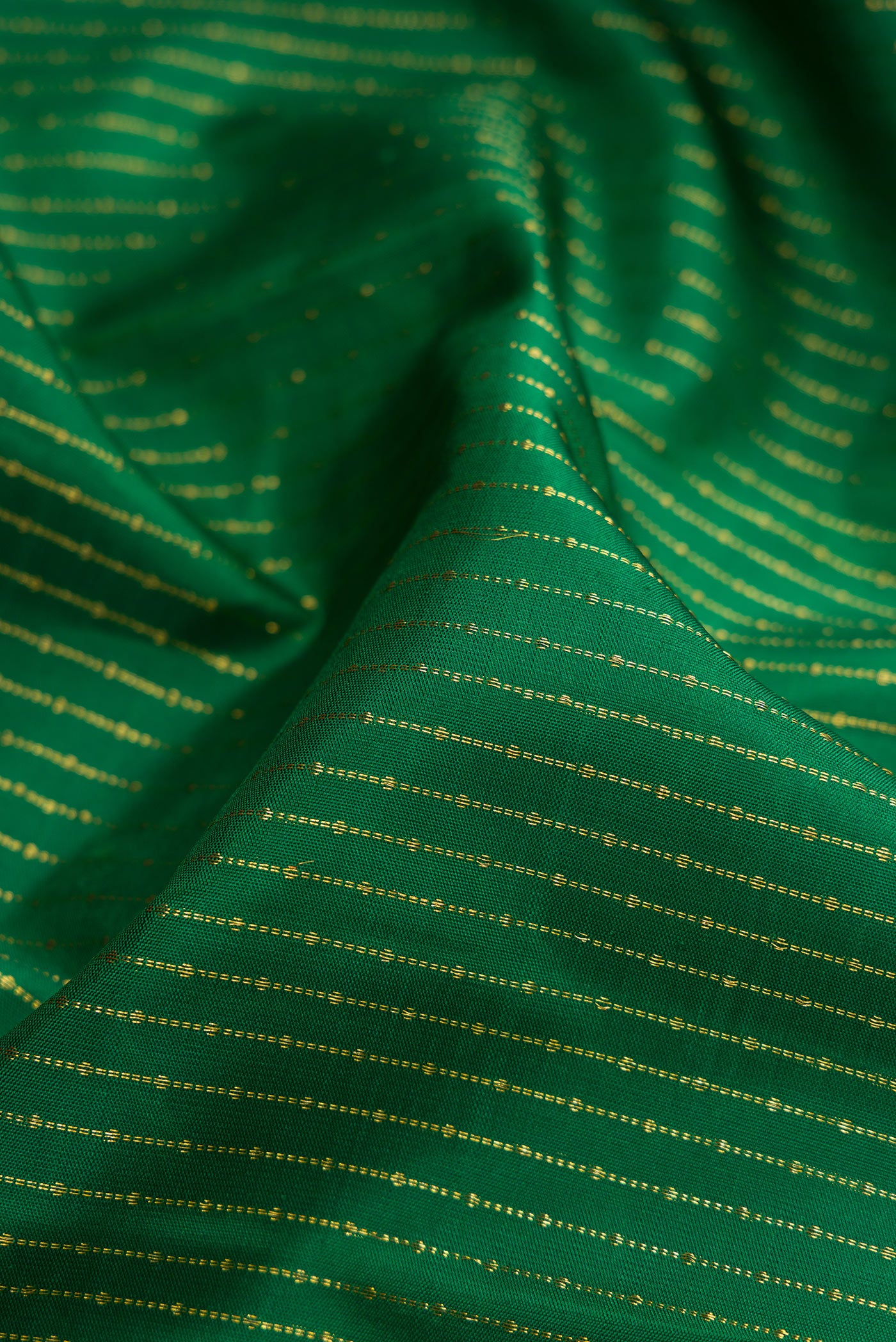 Close up of Bottle Green Kanchipuram Silk Saree with Stripes on the body and Zari Border.  displaying folds