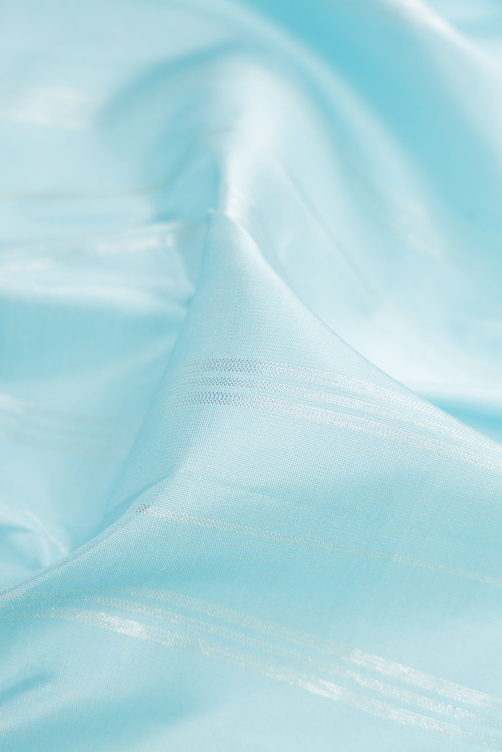 Close up of Light Blue Kanjivaram Silk Saree with Stripes on the body and Without Border.  displaying folds