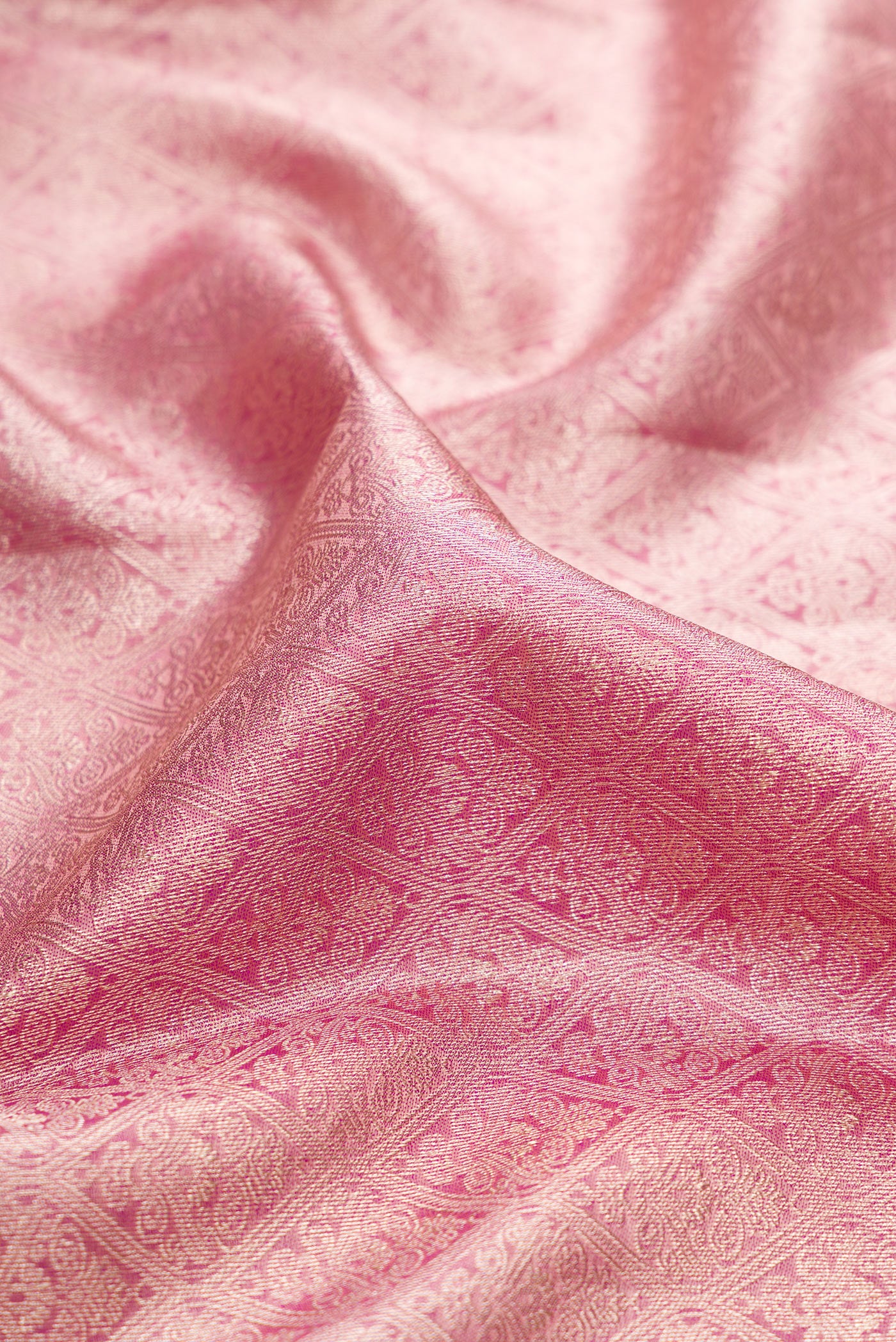Close up of Rose Gold Kanchipuram Silk Saree with Zari Brocade on the body and Zari Border.  displaying folds
