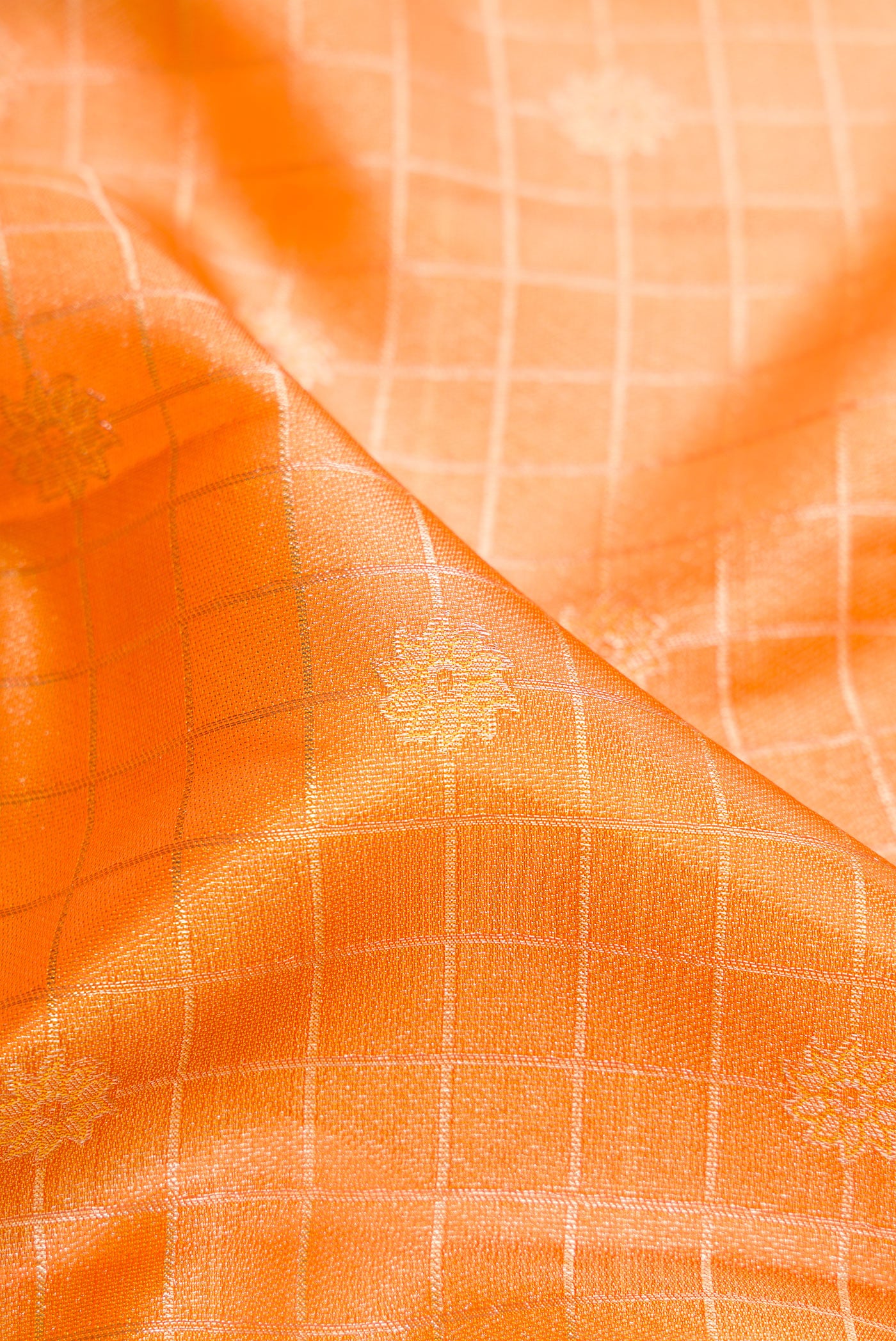 Close up of Orange Dual Tone Kanchipuram Tissue Silk Saree with Zari Brocade on the body and Fancy Border.  displaying folds