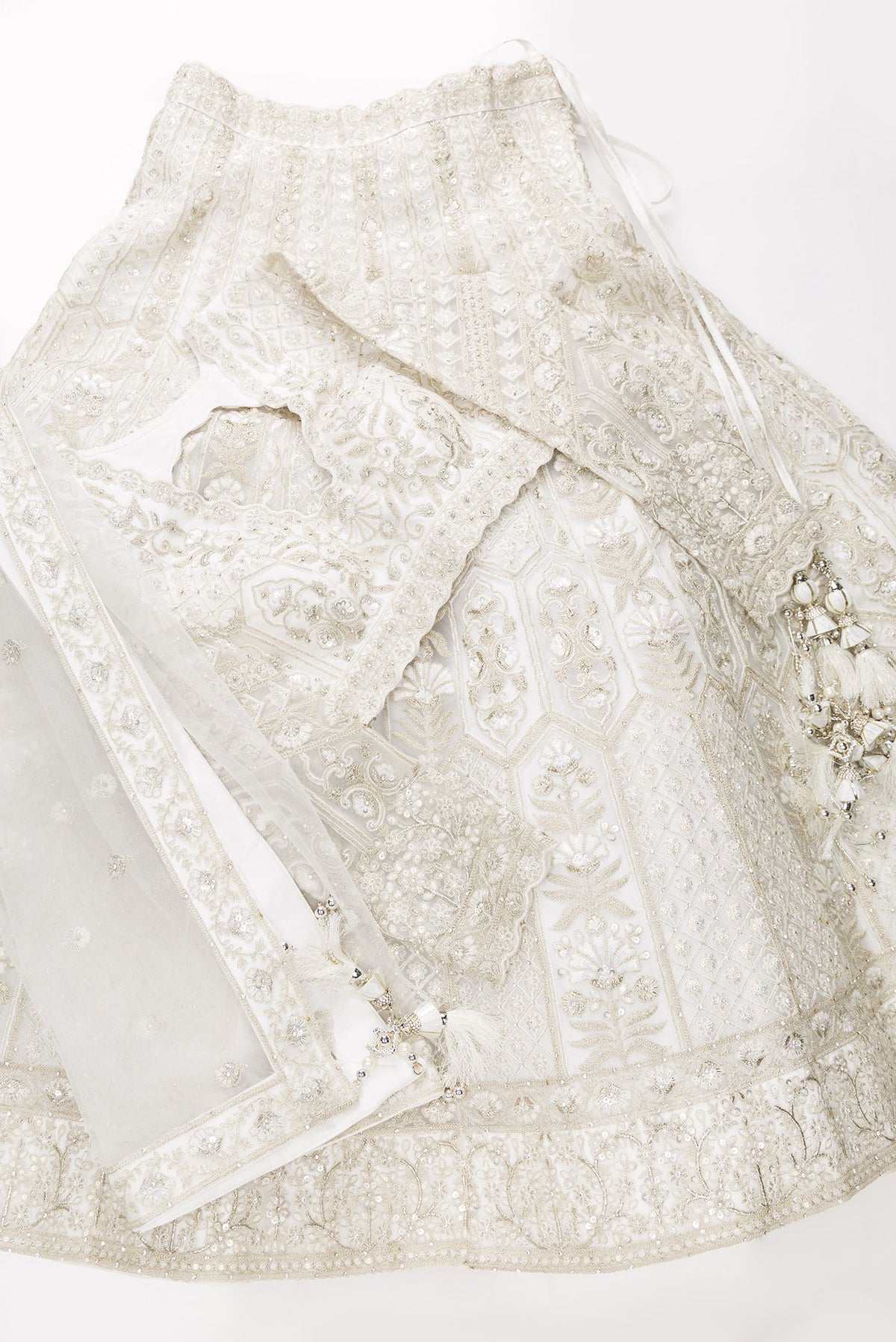 Flat lay of Off White Banarasi Silk Womens Lehenga set featuring Embroidered Choli paired with Off White Embroidered Skirt with Embroidered Border and a Embroidered dupatta in Off White