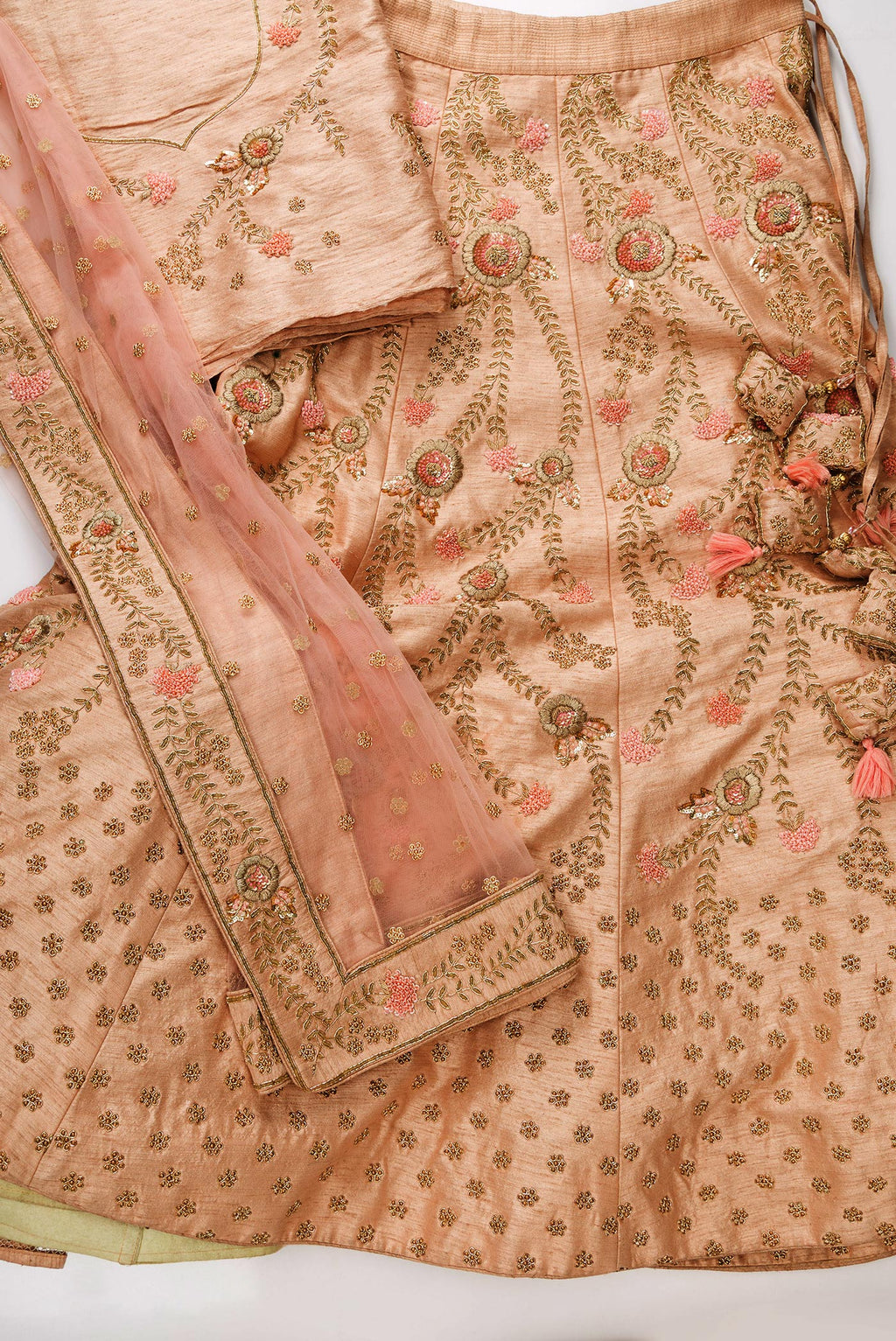 Flat lay of Rose Gold Banarasi Silk Womens Lehenga set featuring Embroidered Choli paired with Rose Gold Embroidered Skirt with Embroidered Border and a Embroidered dupatta in Rose Gold