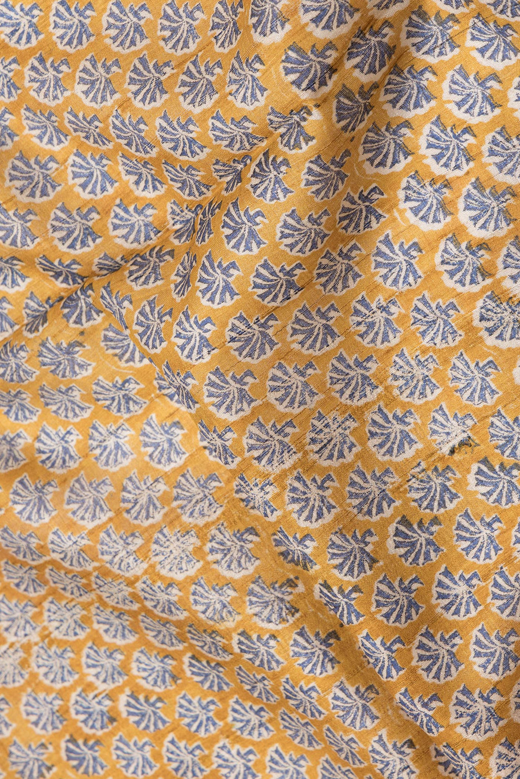 Close up of Mustard Dual Tone Tussar Silk Saree with Printed design on the body and Zari Border.  displaying folds