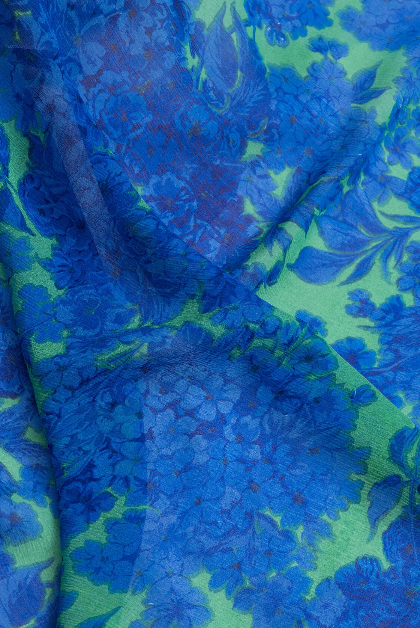 Close up of Parrot Green Dual Tone Mysore Chiffon Saree with Printed design on the body and Zari Border.  displaying folds