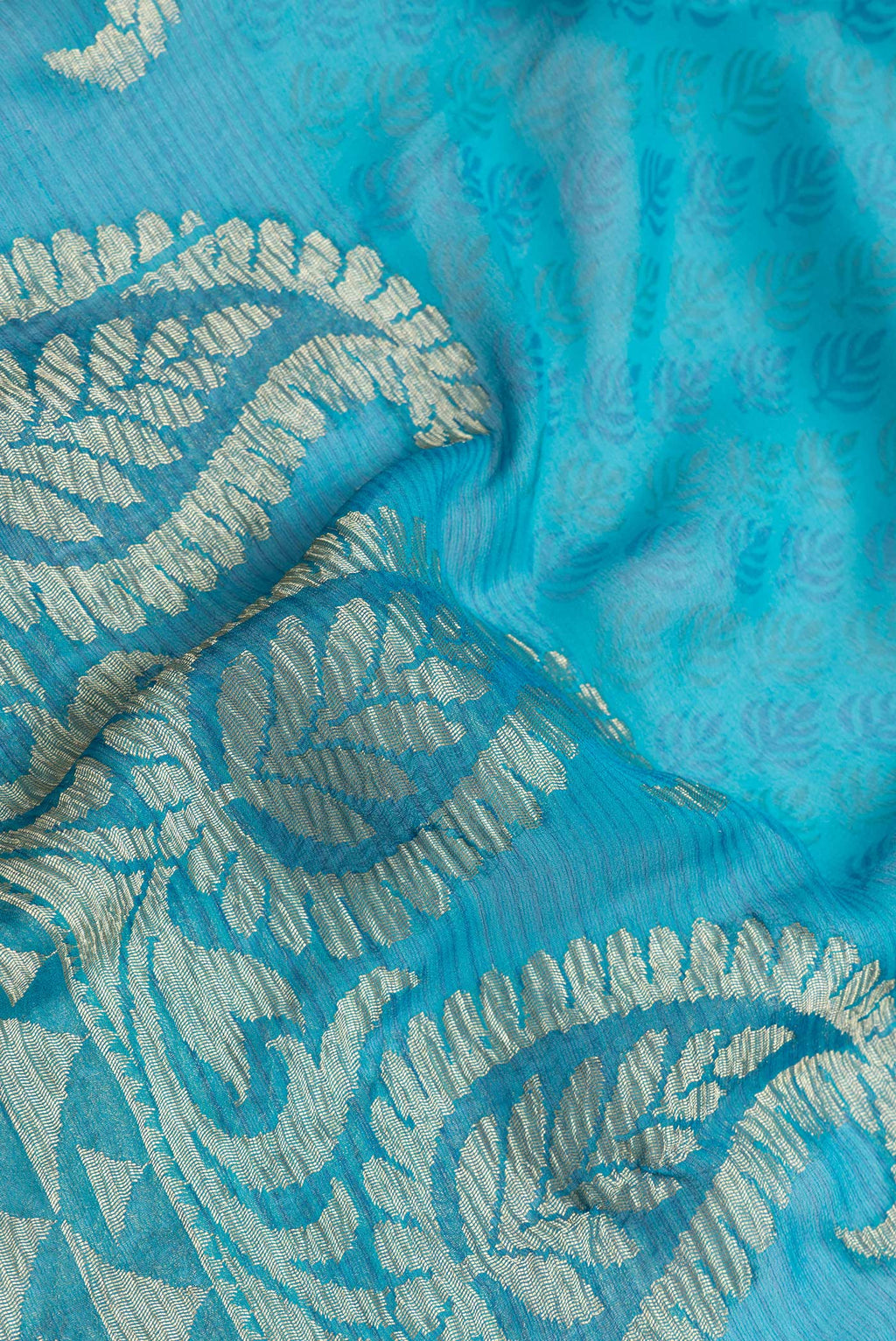 Close up of Sky Blue Dual Tone Mysore Georgette Saree with Zari Butta on the body and Zari Border.  displaying folds