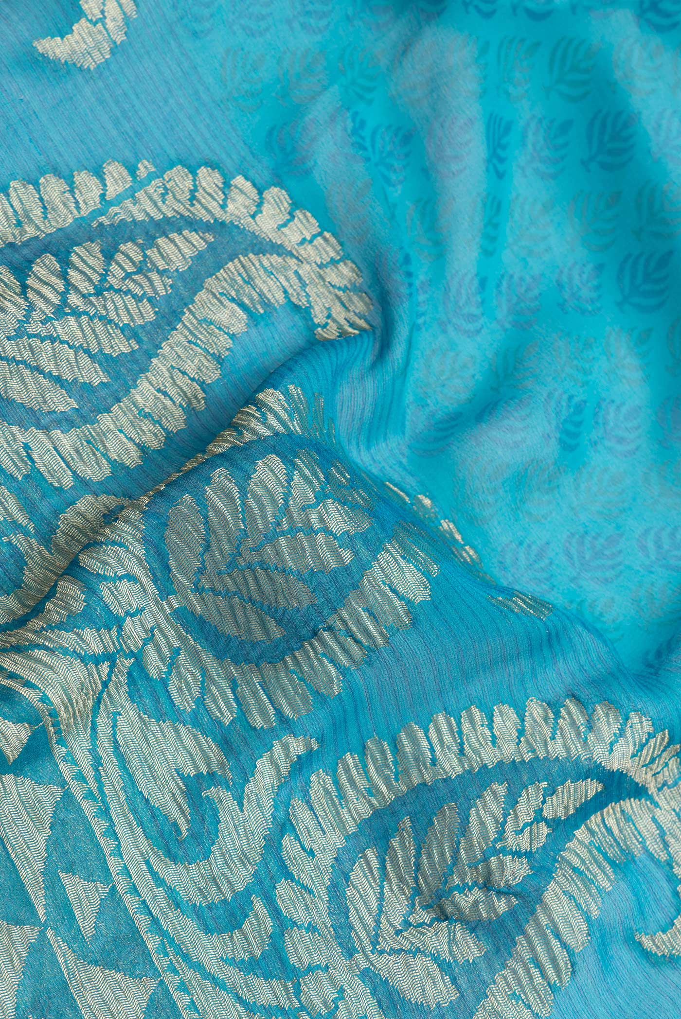 Close up of Sky Blue Dual Tone Mysore Georgette Saree with Zari Butta on the body and Zari Border.  displaying folds