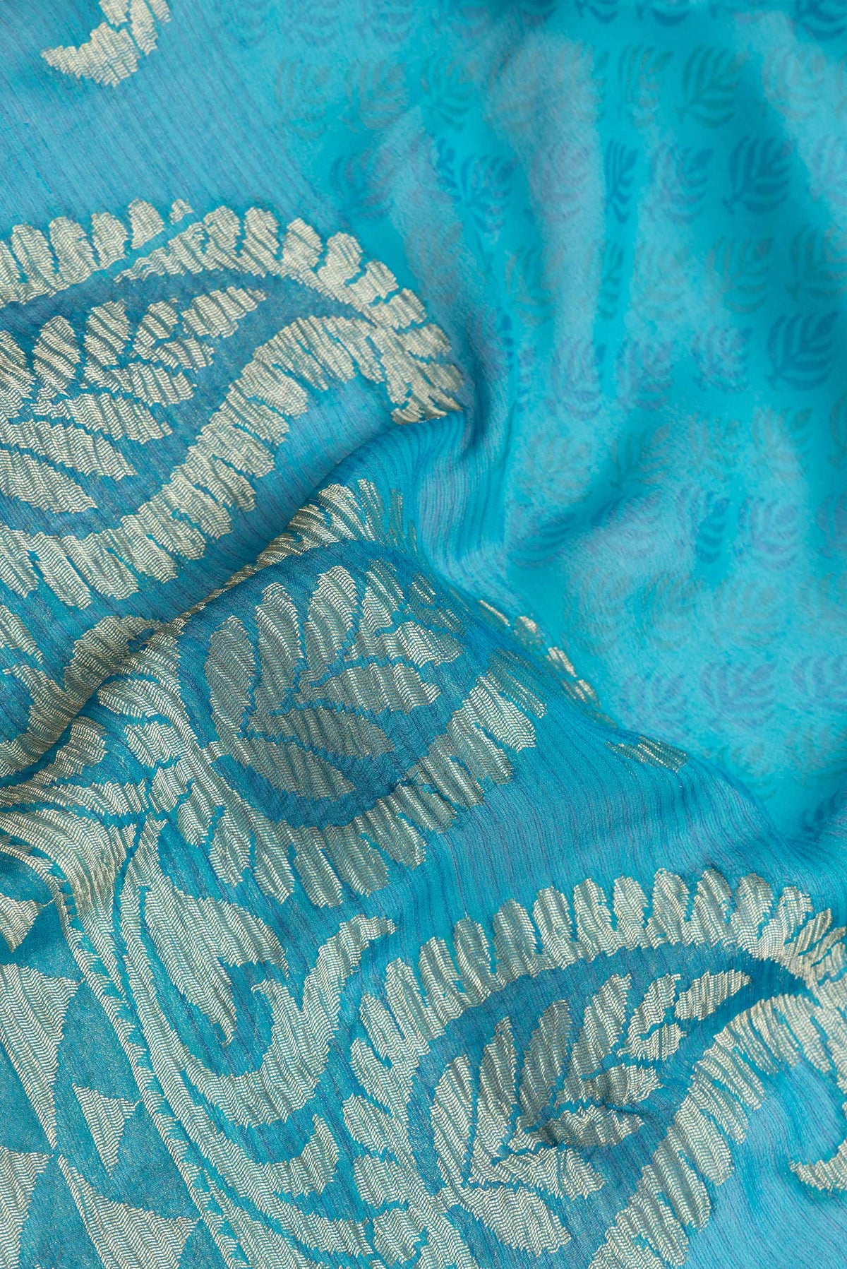 Close up of Sky Blue Dual Tone Mysore Georgette Saree with Zari Butta on the body and Zari Border.  displaying folds