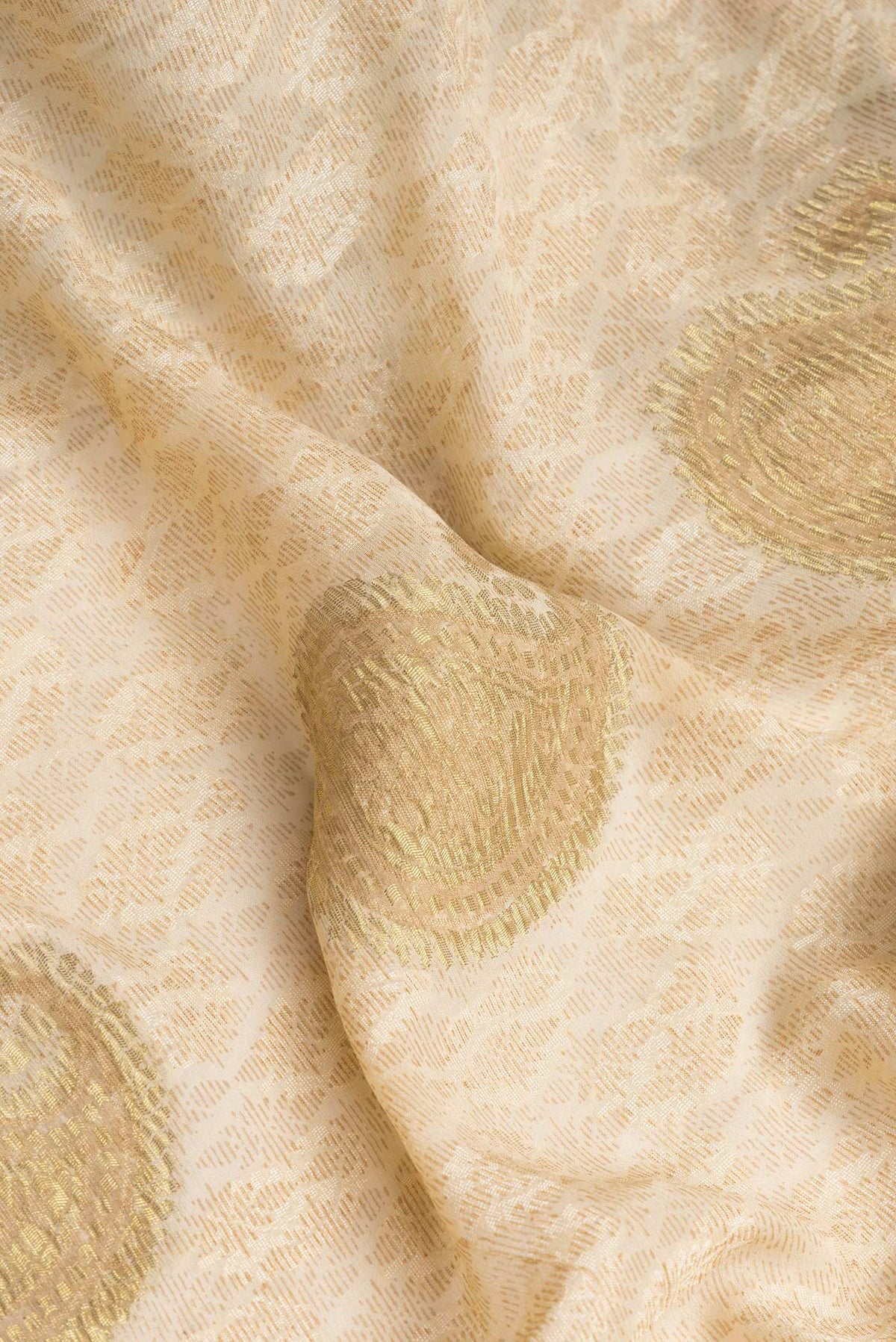 Close up of Beige Dual Tone Mysore Georgette Saree with Zari Butta on the body and Zari Border.  displaying folds