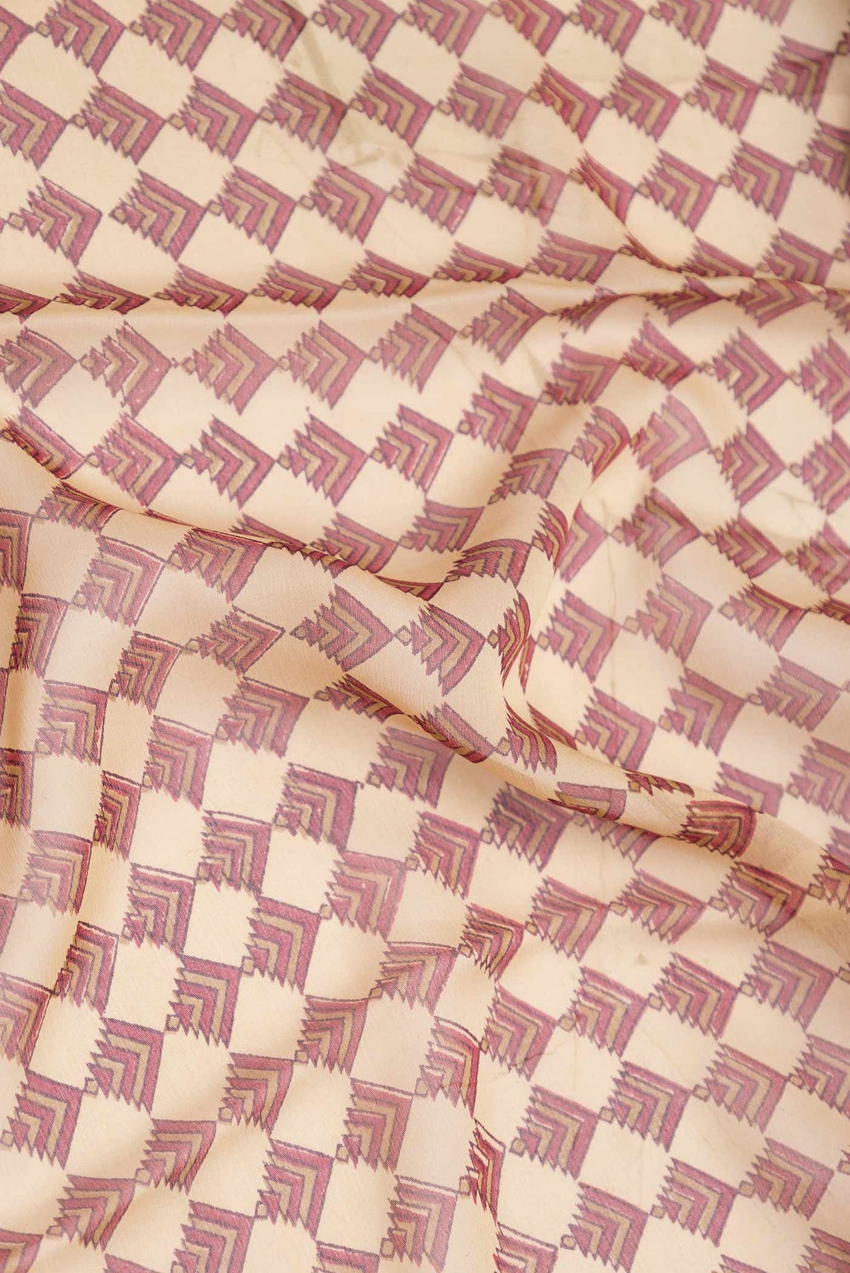 Close up of Beige Dual Tone Mysore Georgette Saree With Printed design on the body and Zari Border displaying folds