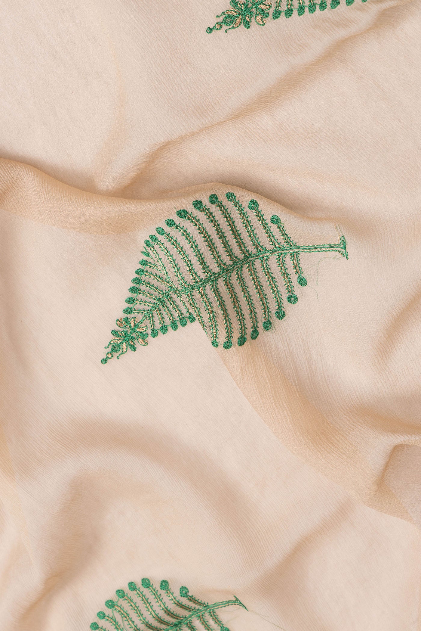 Close up of Beige Dual Tone Mysore Chiffon Saree with Embroidery on the body and Zari Border.  displaying folds