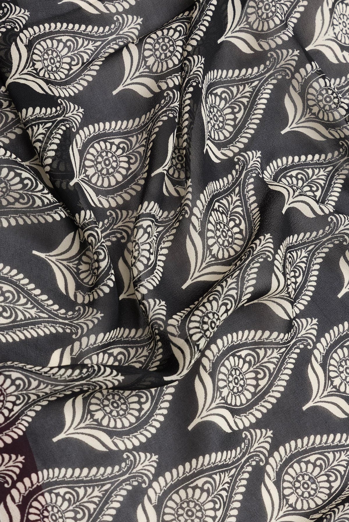 Close up of Black Dual Tone Mysore Georgette Saree with Printed design on the body and Zari Border.  displaying folds